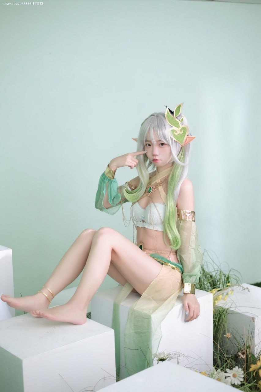 一个穿着绿色和白色衣服的女人坐在地上。