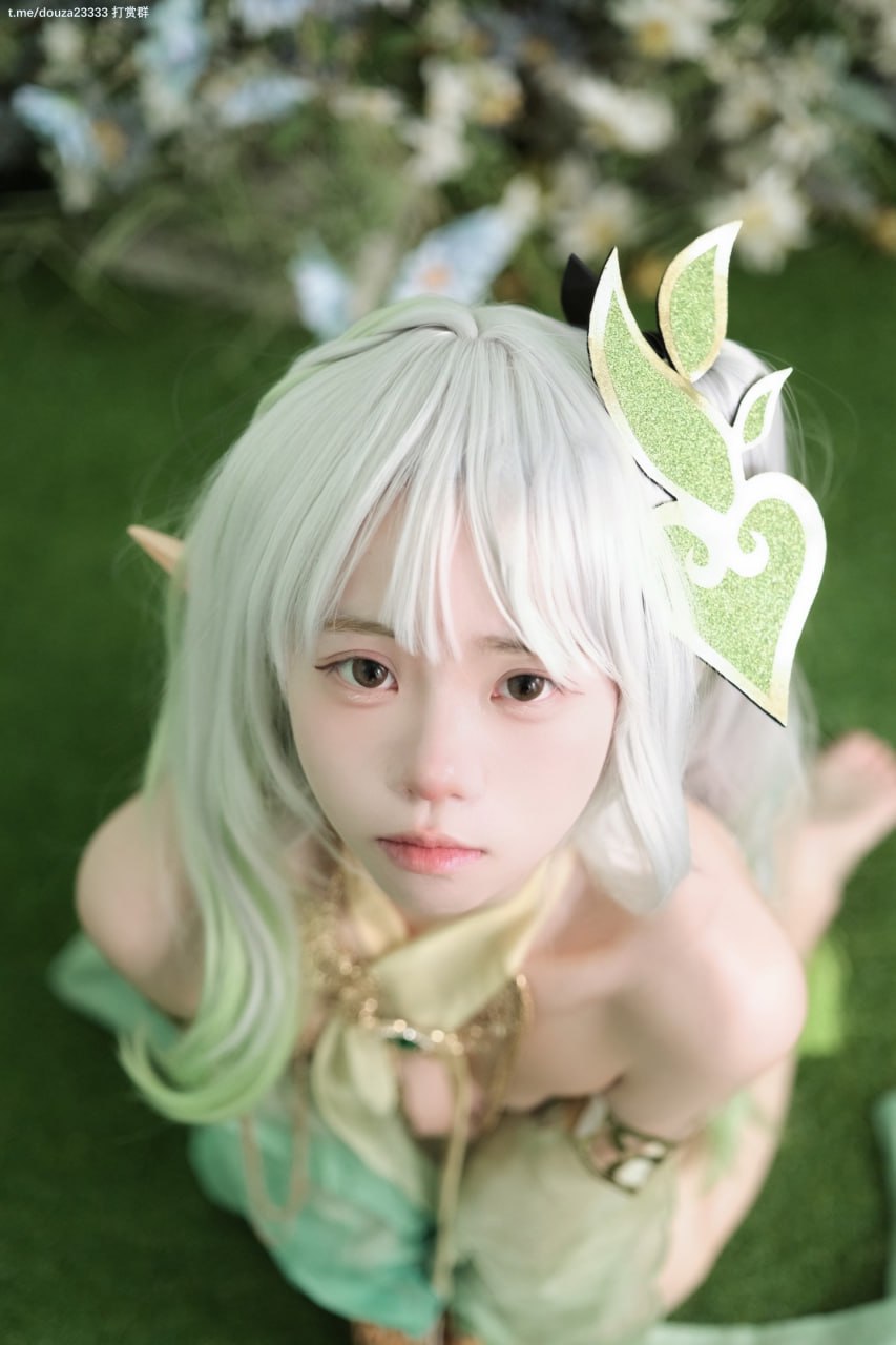 一个穿着绿色和白色衣服的女人坐在地上。