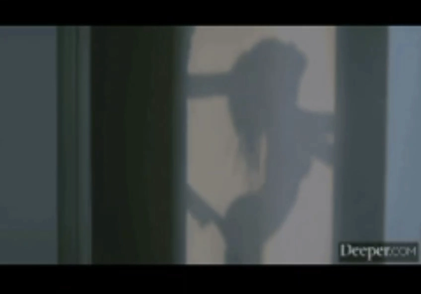 一个女人的影子被扔在一个白色的门上。