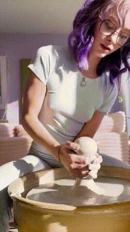 一个紫色头发的女人握着一只骨头。