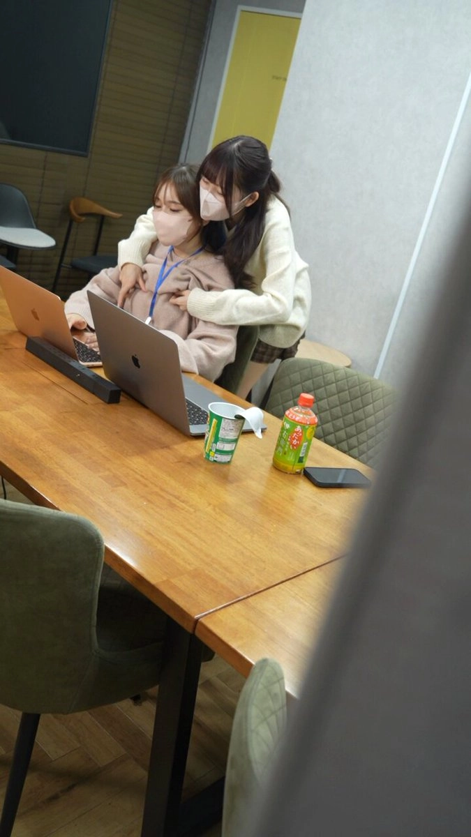 两个女孩互相拥抱,其中戴着面具。