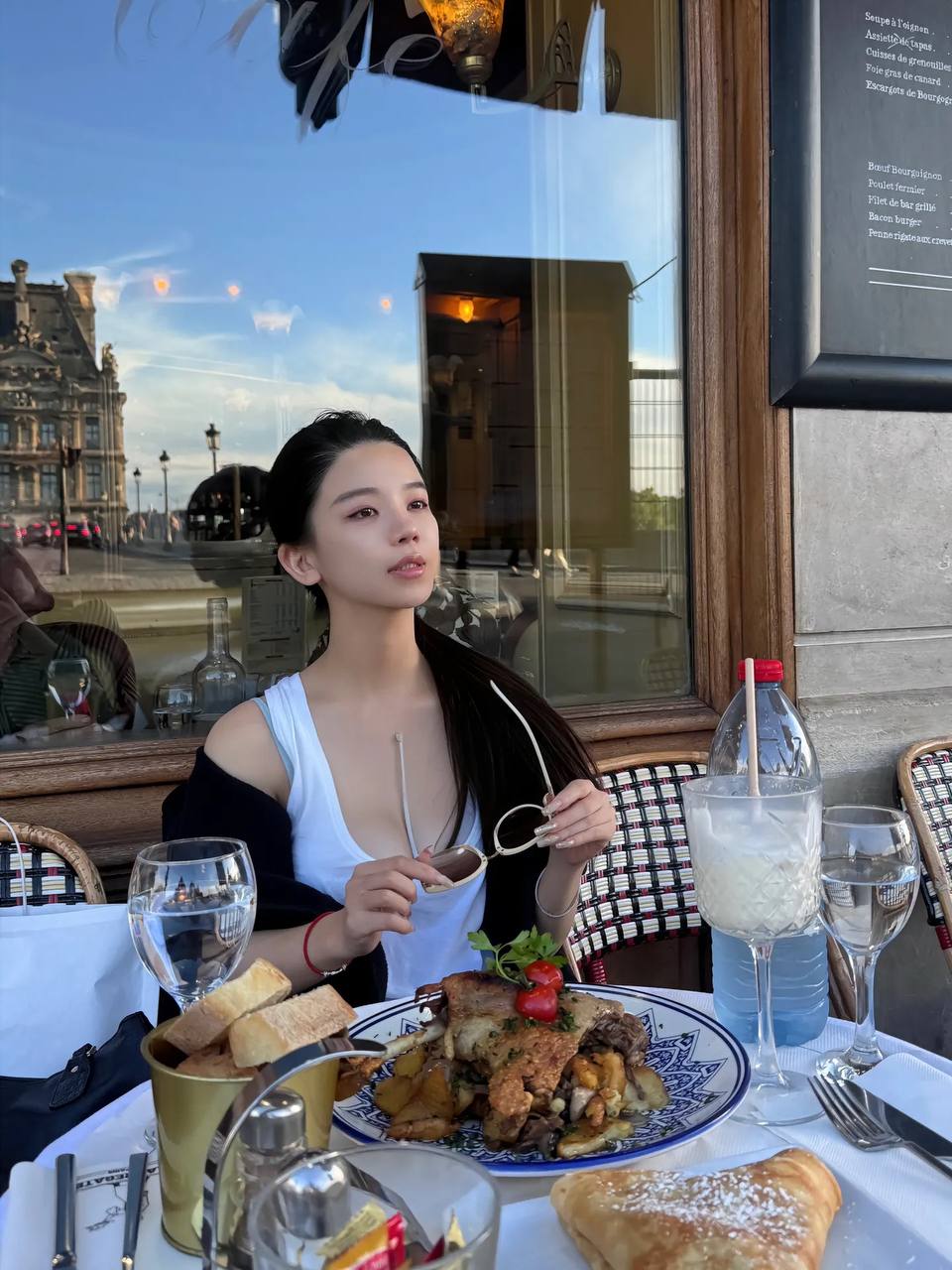 一位穿着比基尼的女人站在阳台上,俯瞰大海。