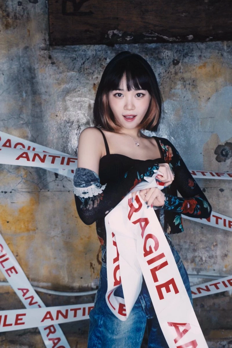 女人拿着一面红色的旗帜,上面写着“RAGILE”。