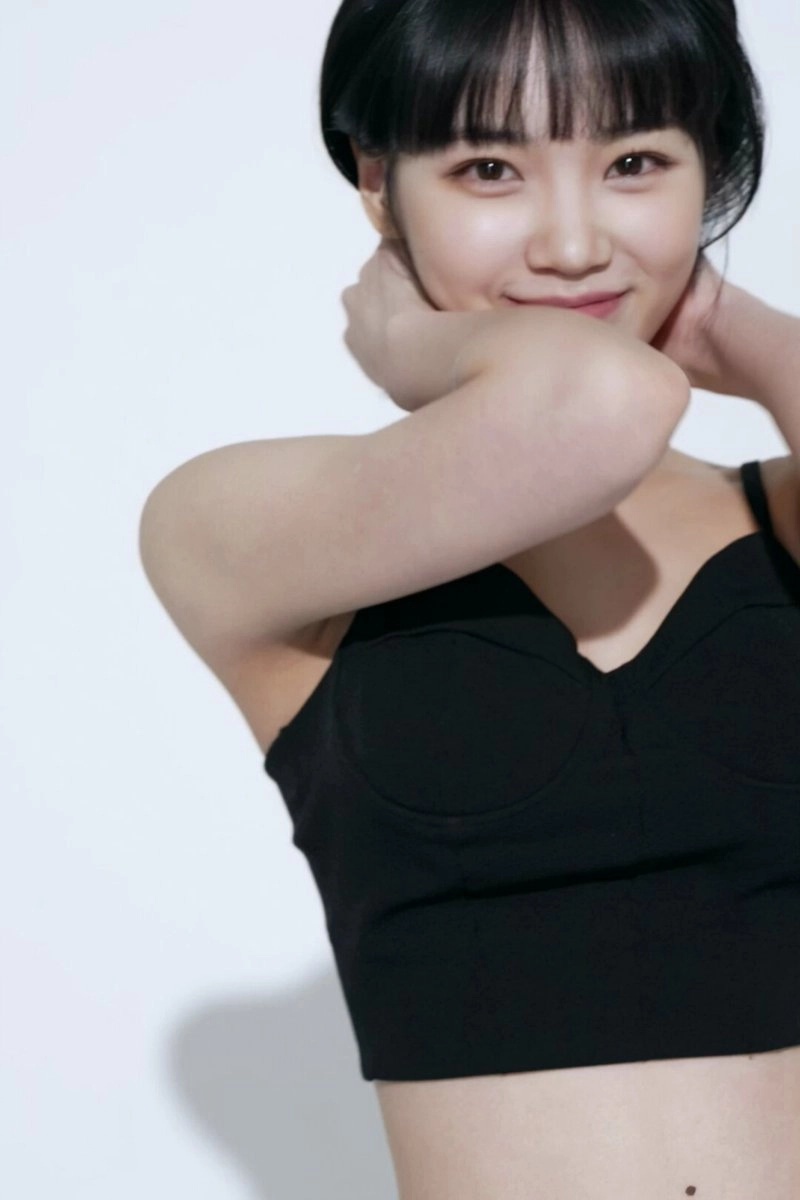 穿着黑色衬衫和黑色头发的女人微笑着。