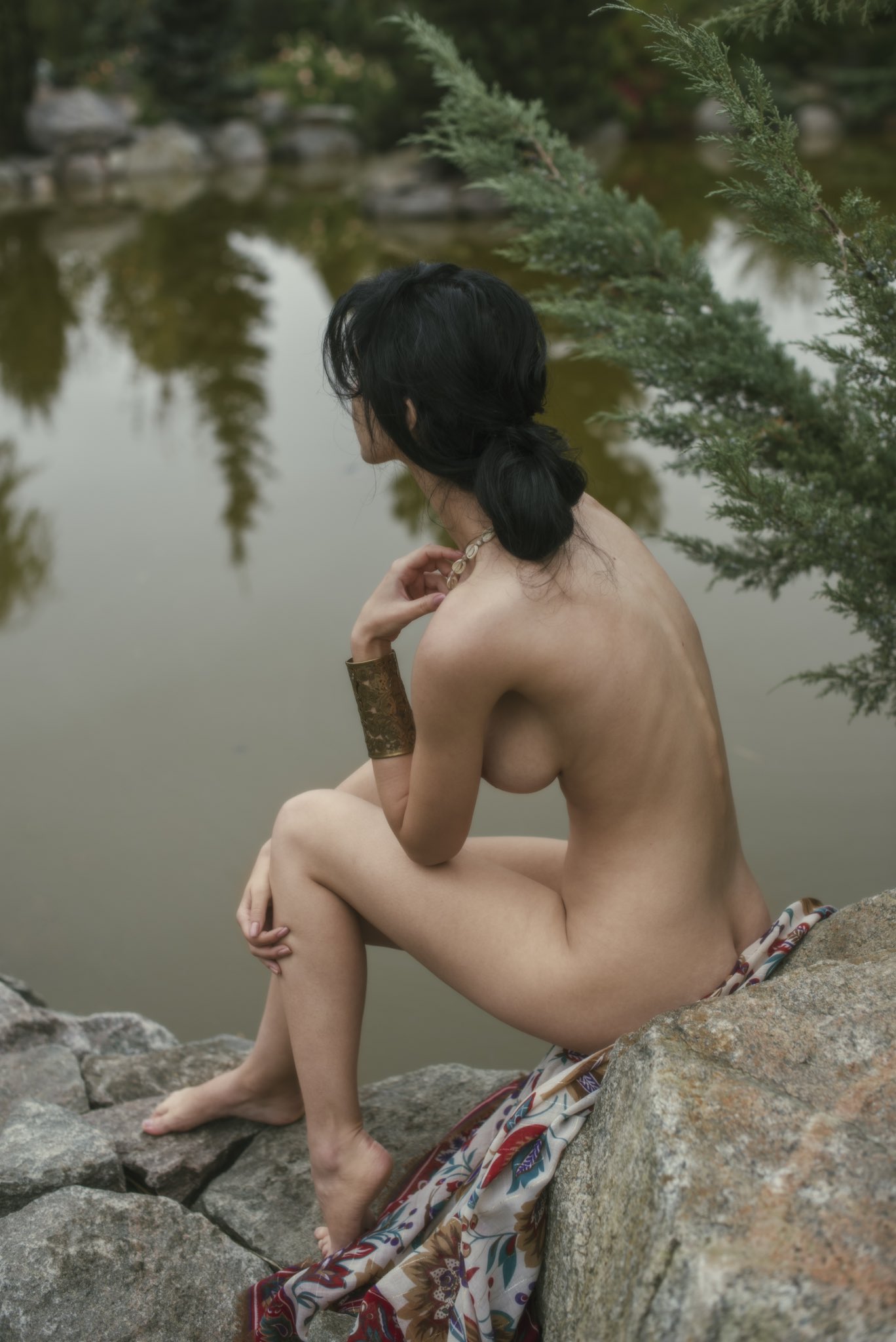 裸体的女人坐在岩石上。