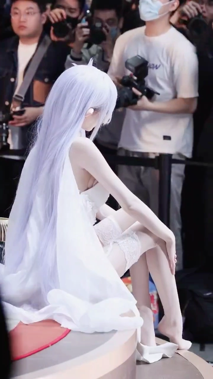 穿着白色裙子和白色袜子的女人坐在椅子上。