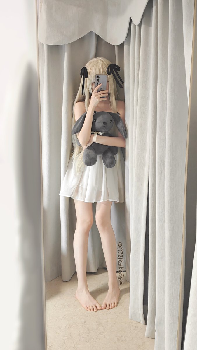 女人在窗帘前抱着一只动物。