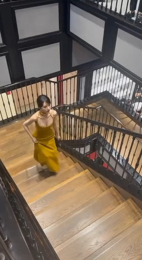 穿着黄色衣服的女人正在爬楼梯。