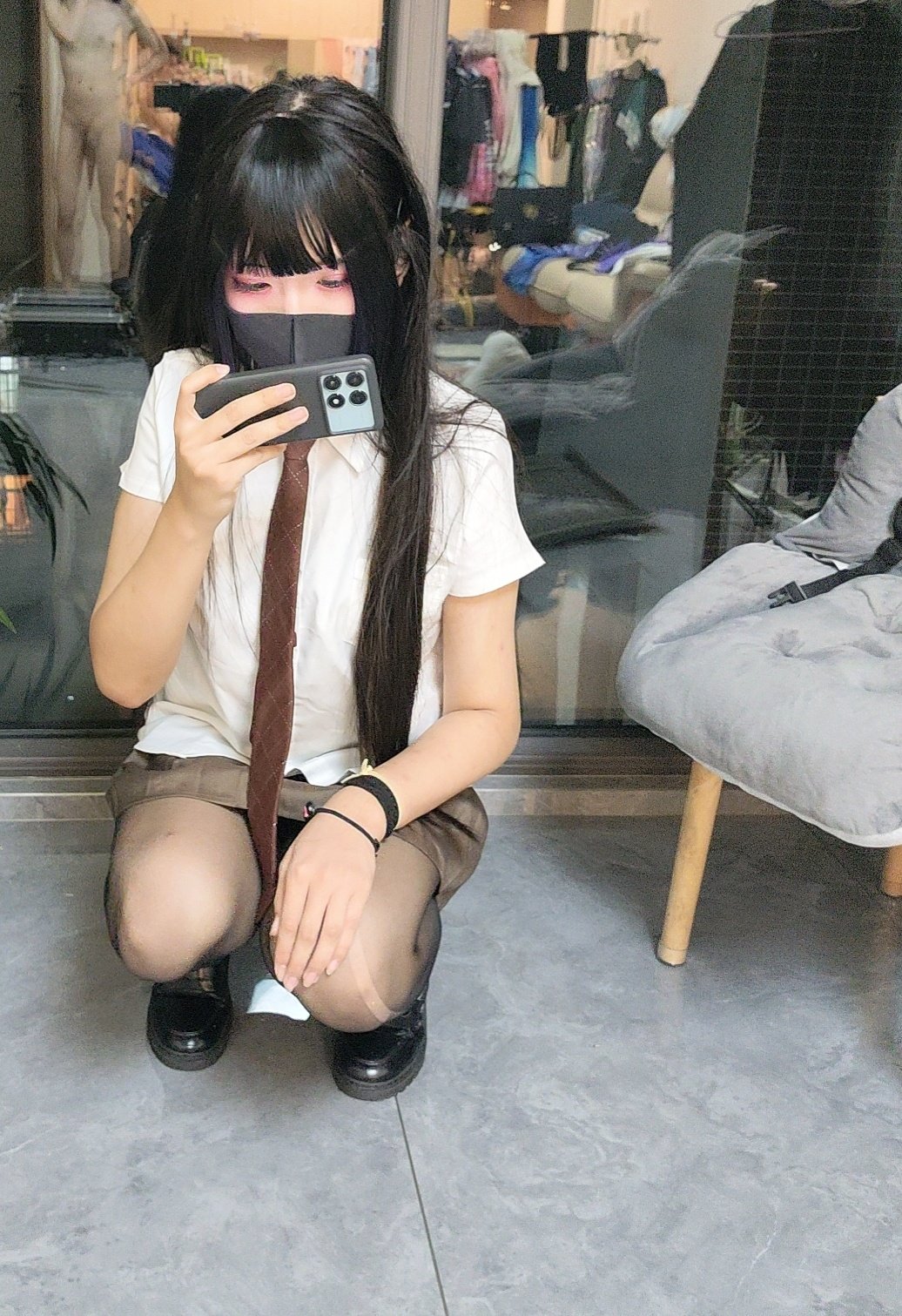 女人穿着一件领带,拿着一个Wii远程。