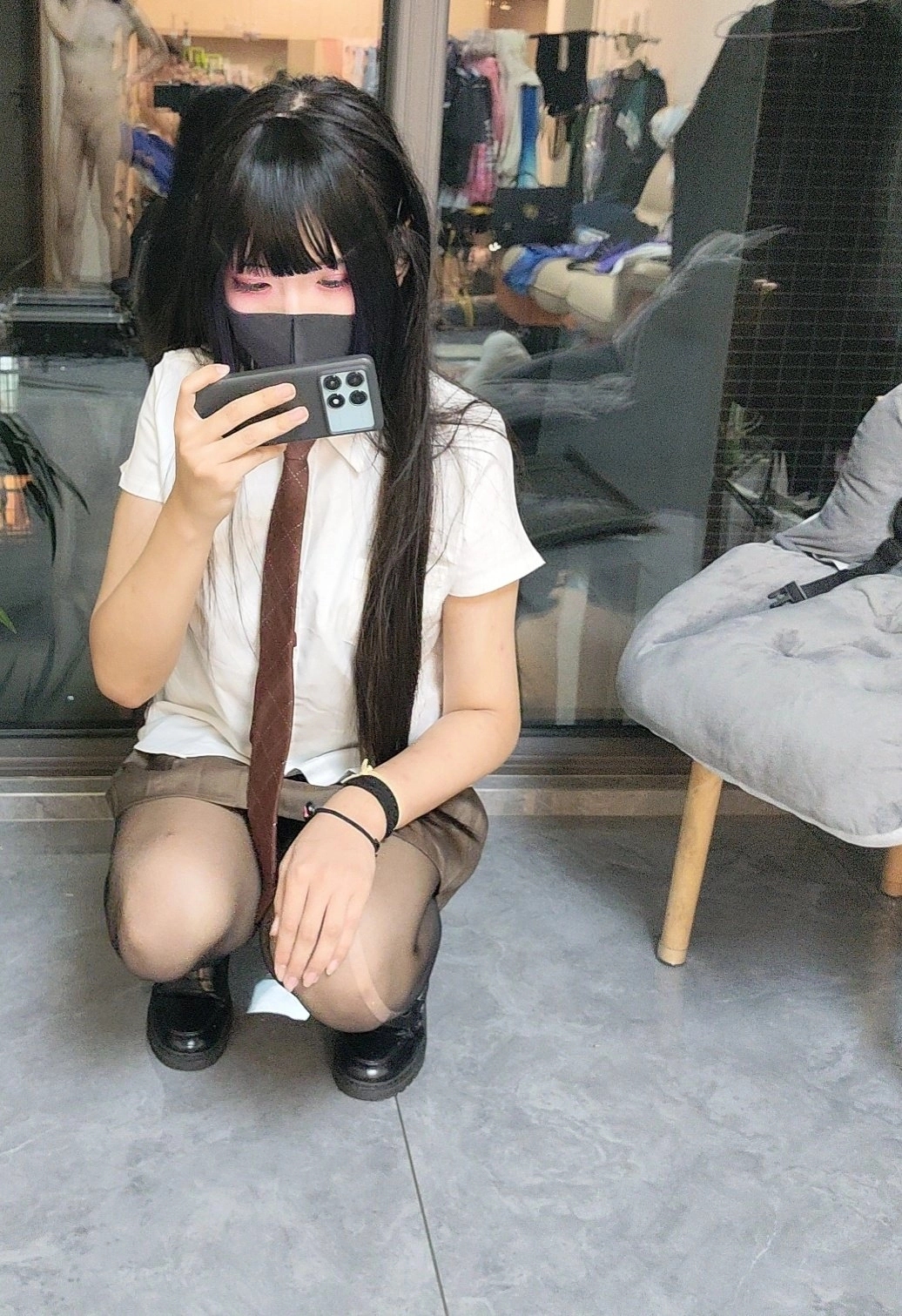 女人穿着一件领带,拿着一个Wii远程。