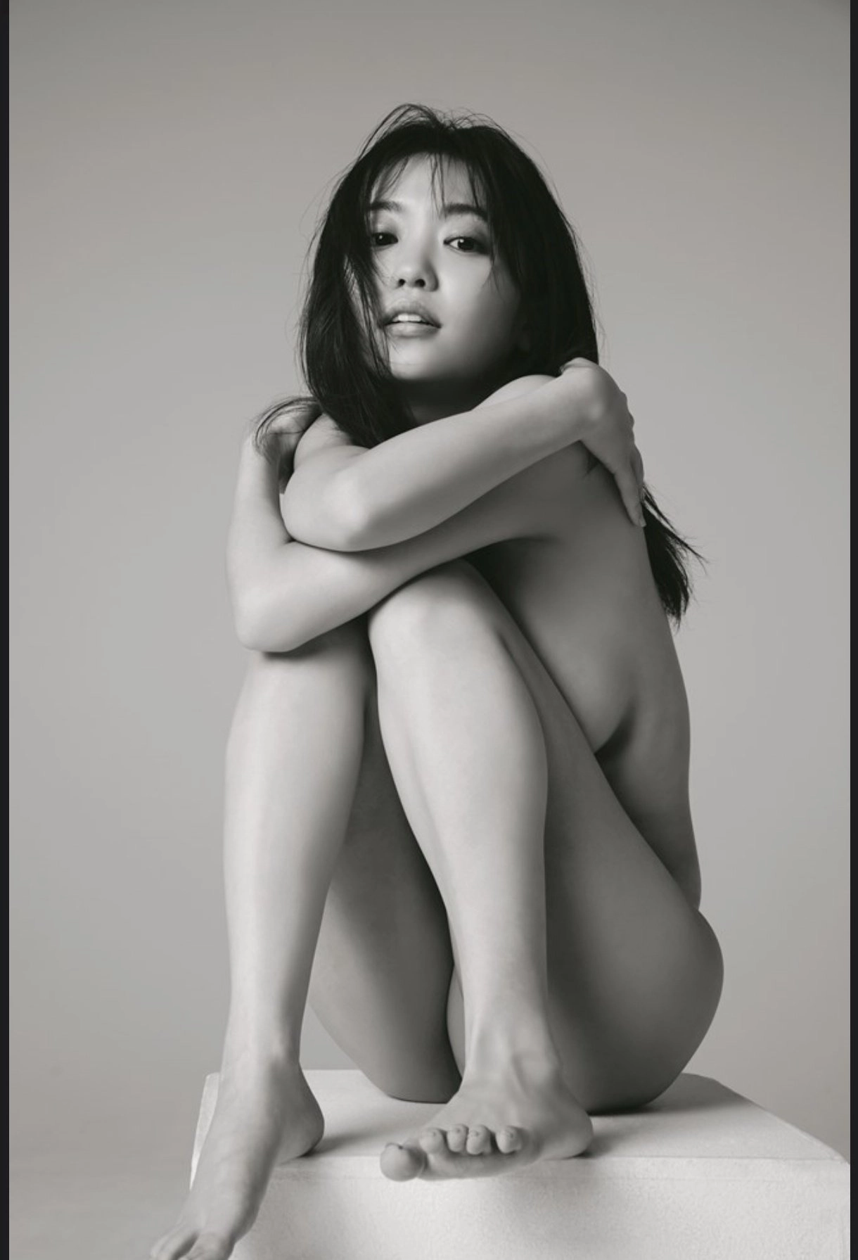 黑头发的女人和一只马尾巴坐在地板上。