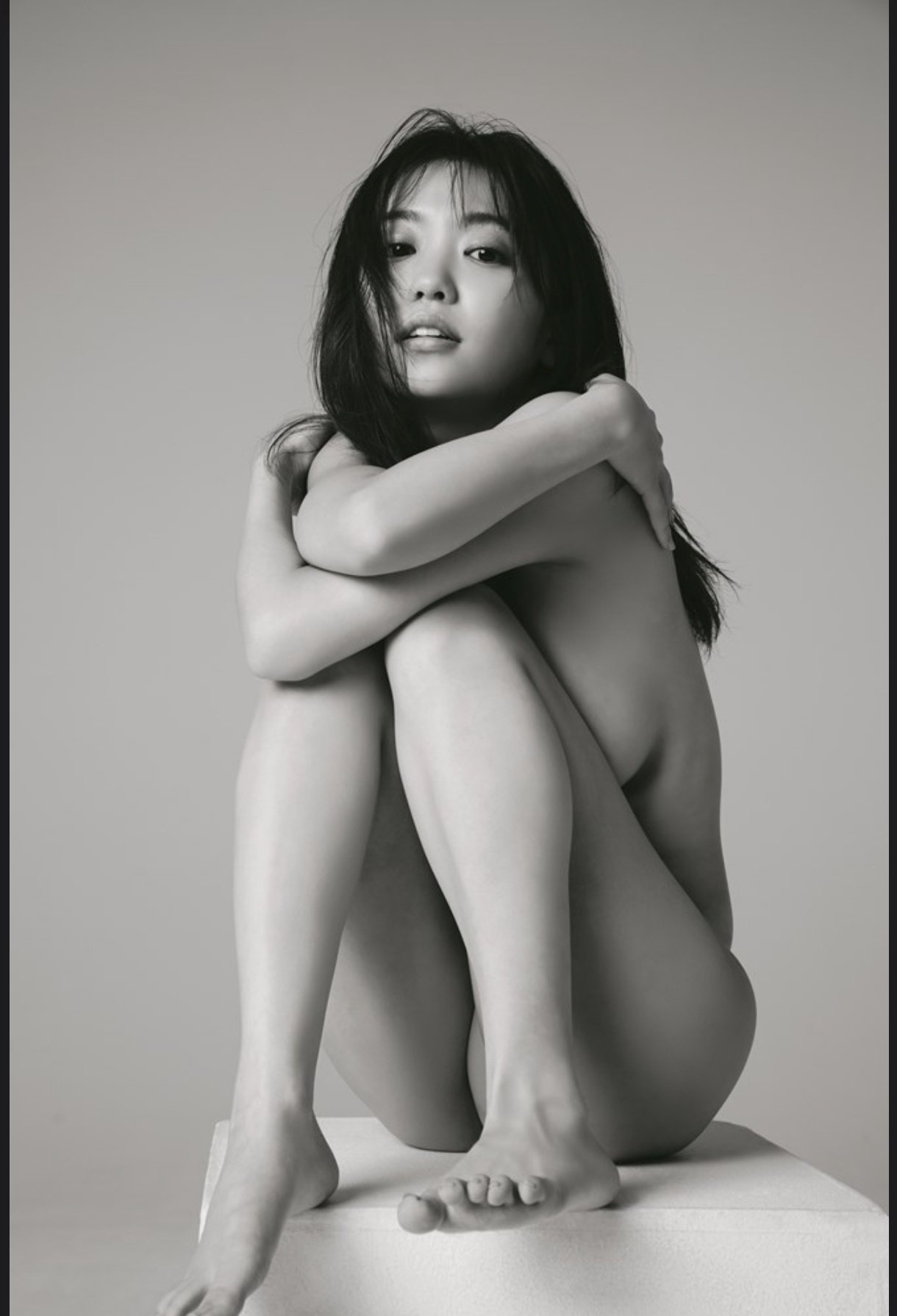 黑头发的女人和一只马尾巴坐在地板上。