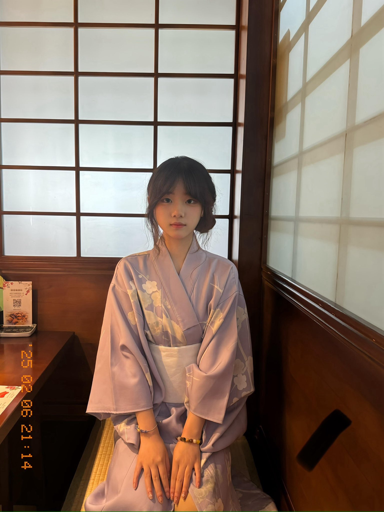 女人穿着紫色吉莫诺坐在一个房间里。