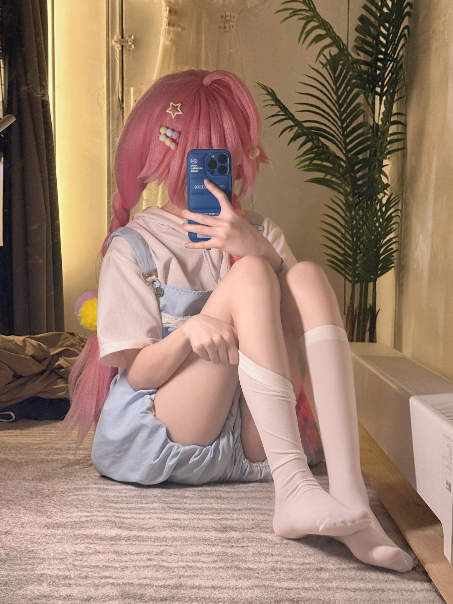 女孩用蓝色手机拍自拍。