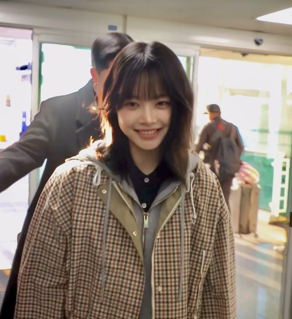 穿着的外套的女人在相机上微笑。