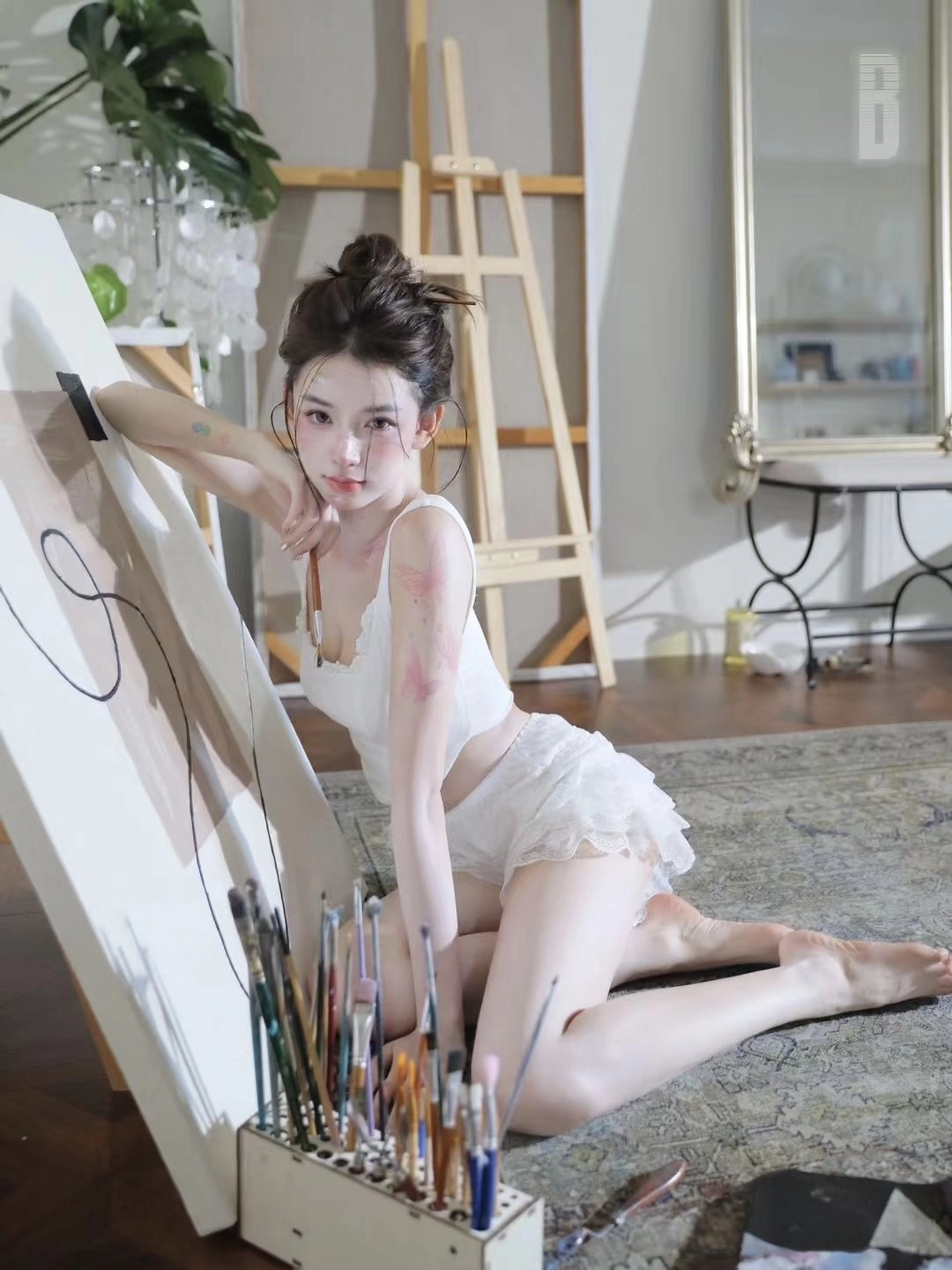 一位穿着白色衣服的女人坐在地板上,双腿交叉。