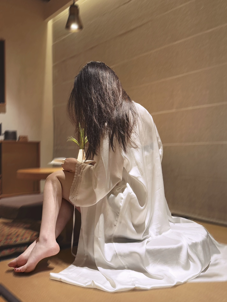 长头发的女人坐在地板上。