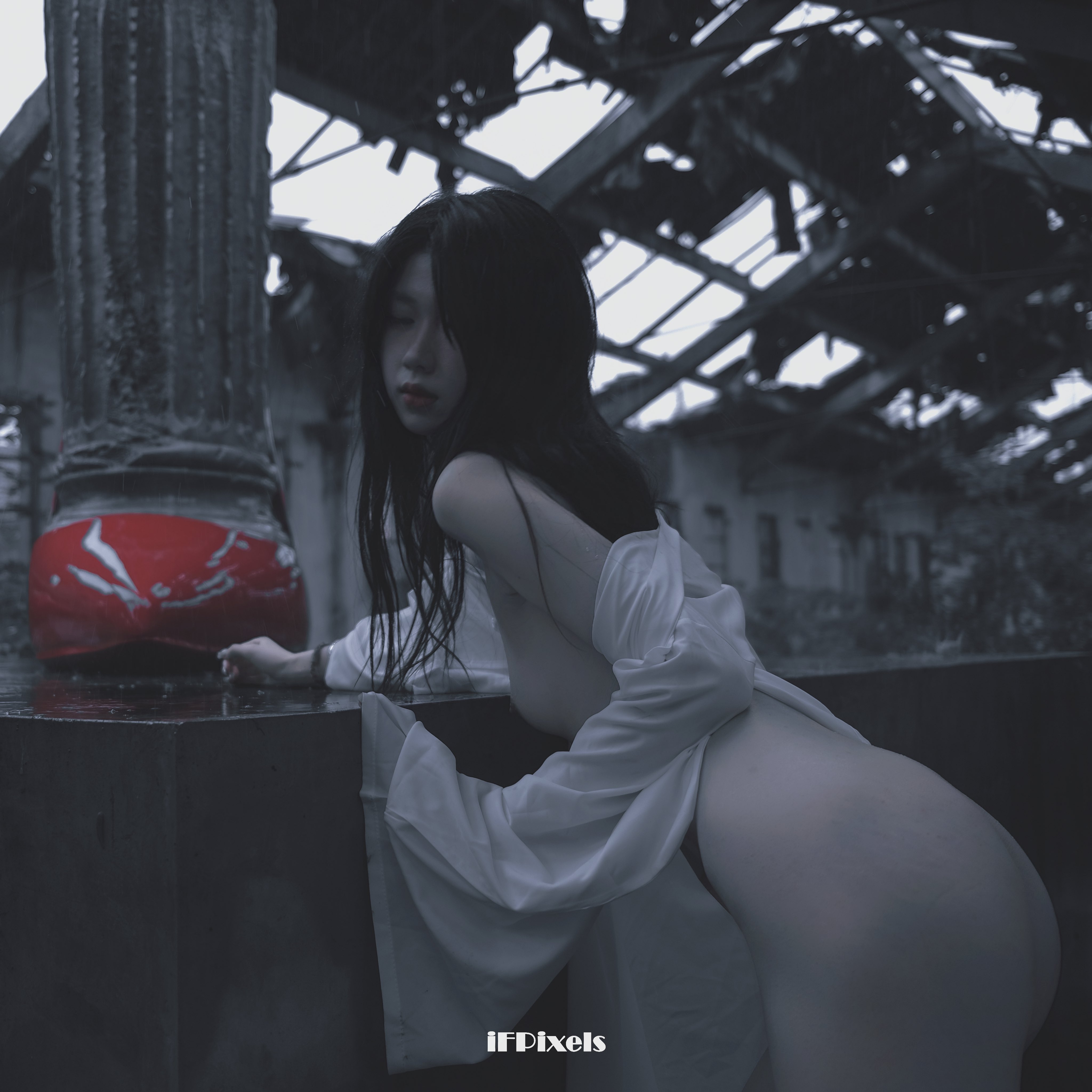 长头发和白色裙子的女人站在一个红色物体旁边。