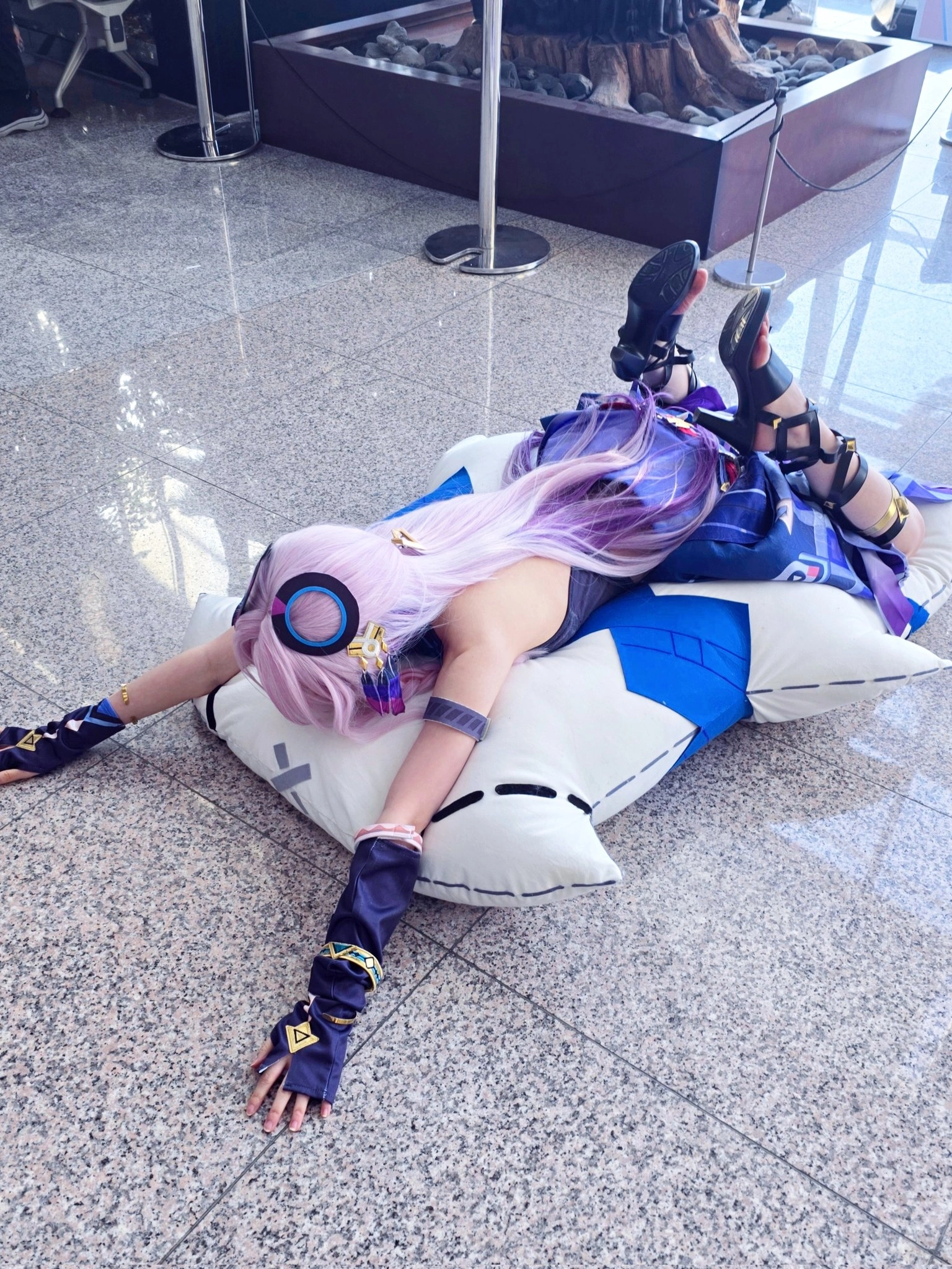 一位穿着紫色裙子和耳机的女人躺在枕头上。