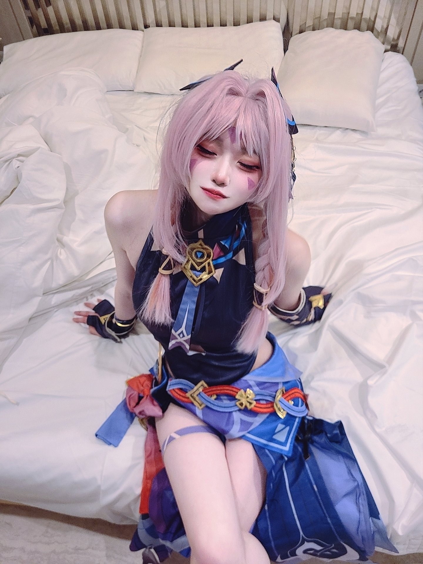 女人穿着蓝色裙子,拿着一把剑坐在床上。