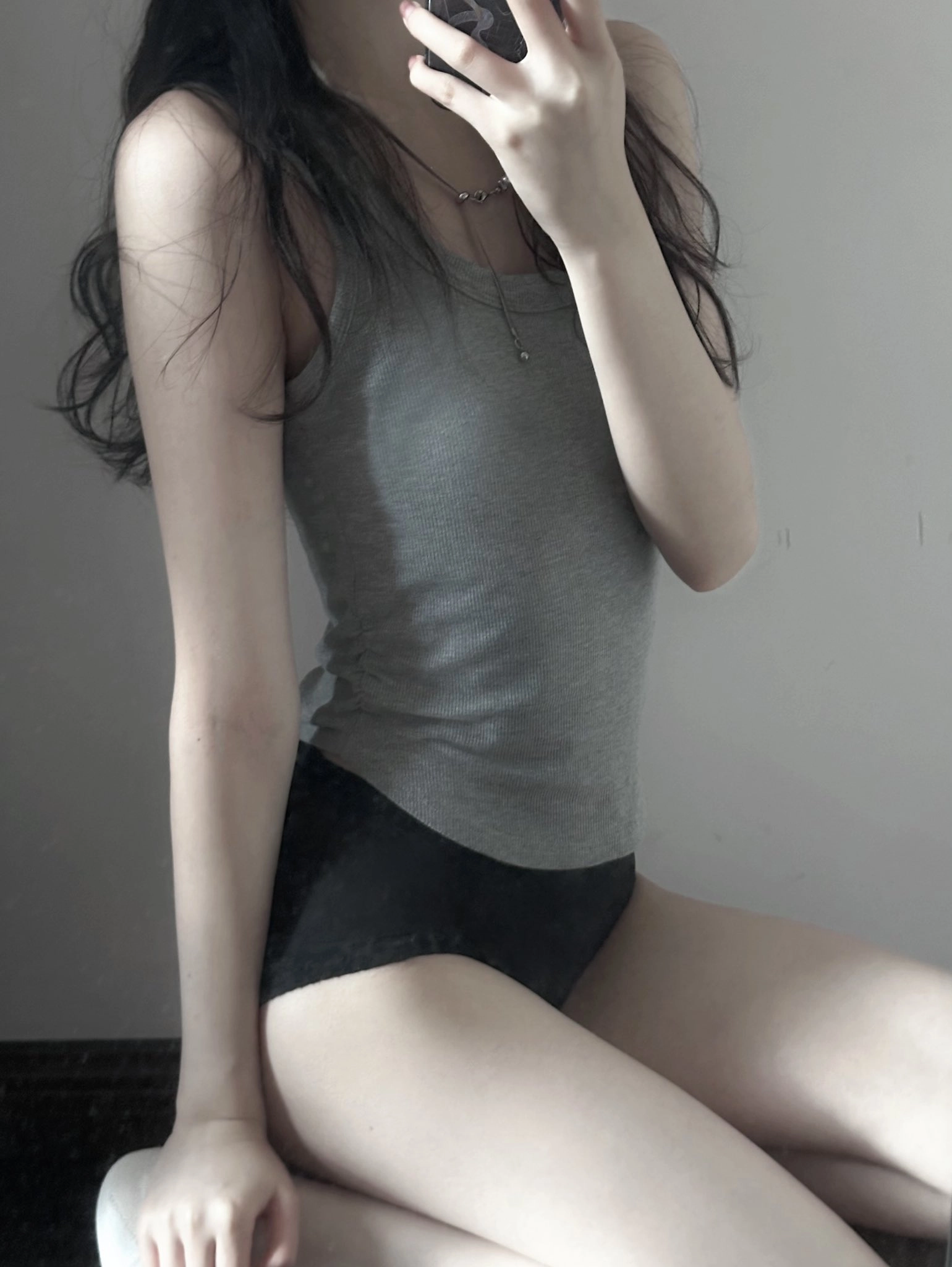 穿着灰色坦克顶的女人刷牙。