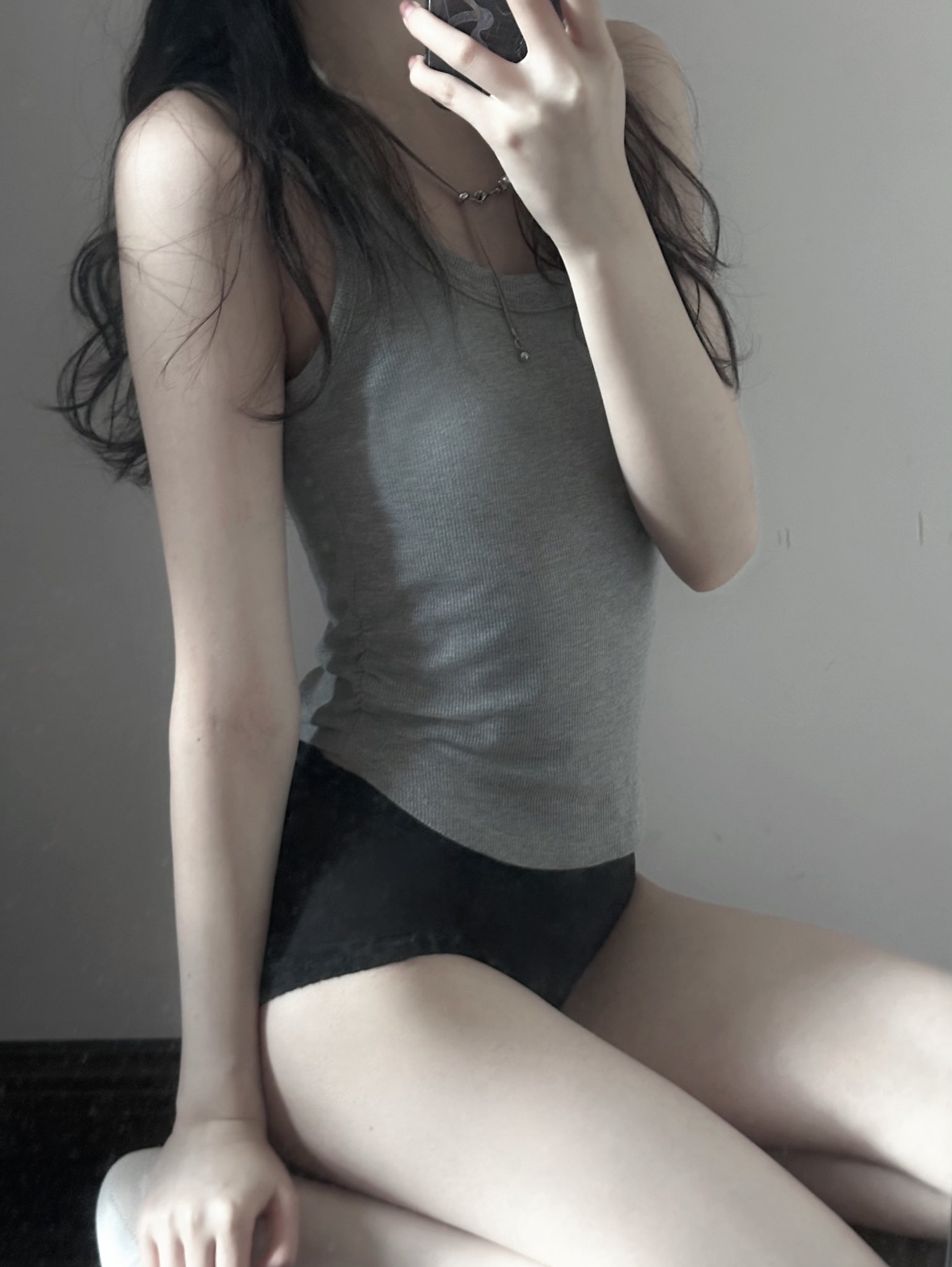 穿着灰色坦克顶的女人刷牙。