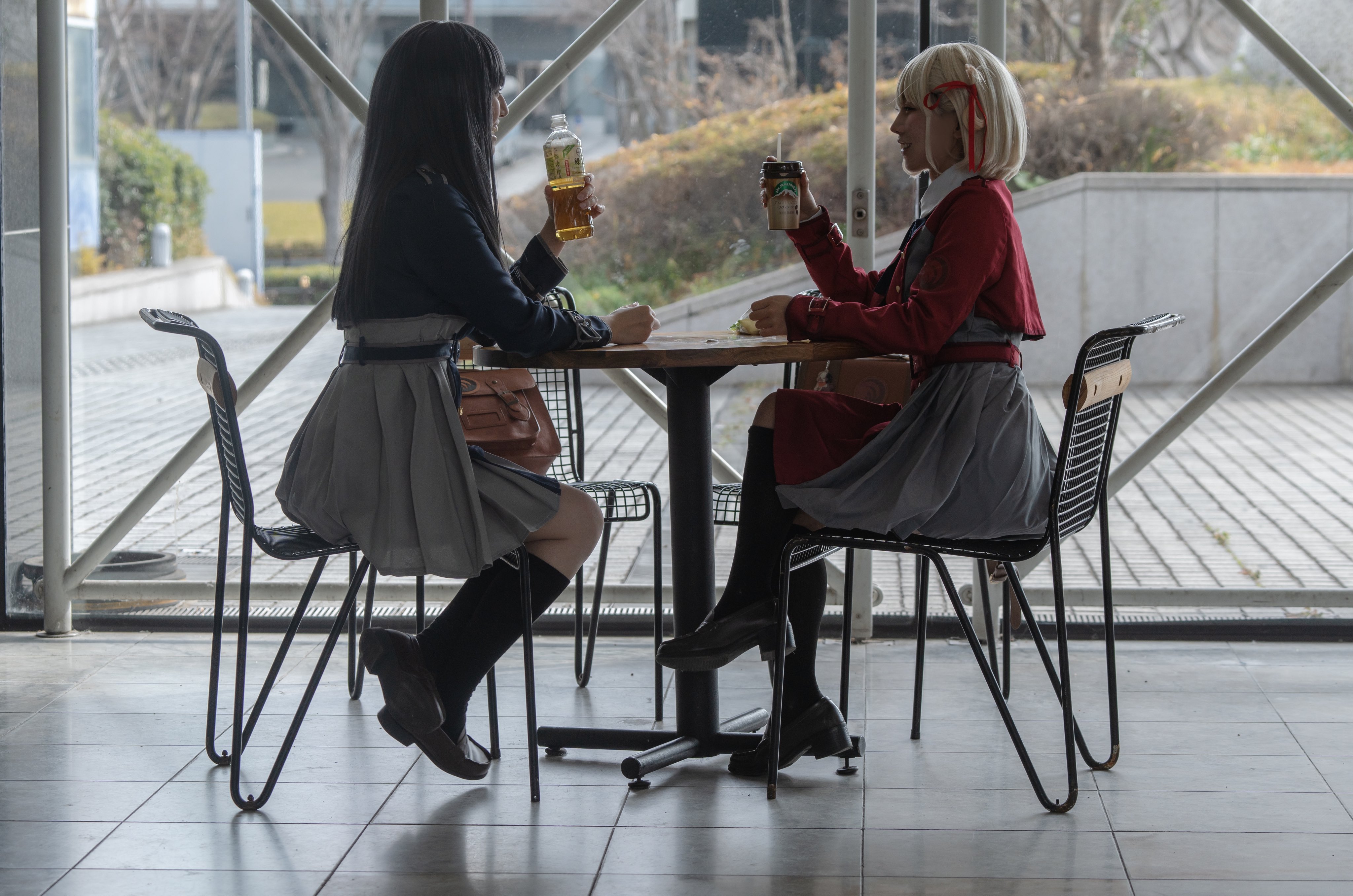 两个女孩坐在一张桌子上,享受饮料和对话。