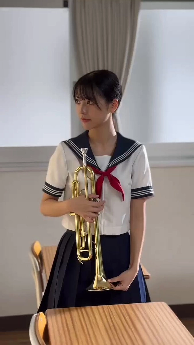 穿着水手服的女人拿着铜器。