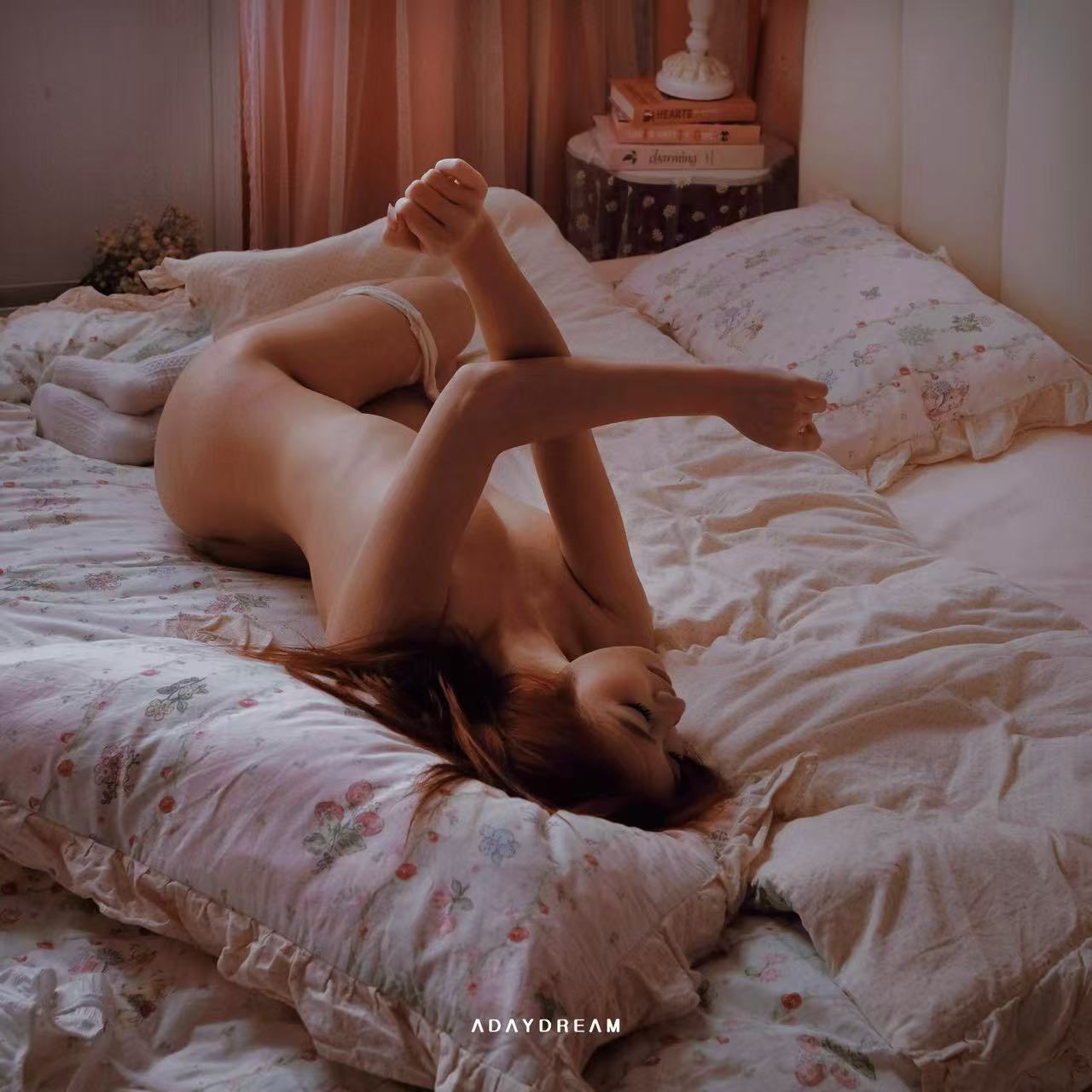 女人躺在床上,腿抬起来。