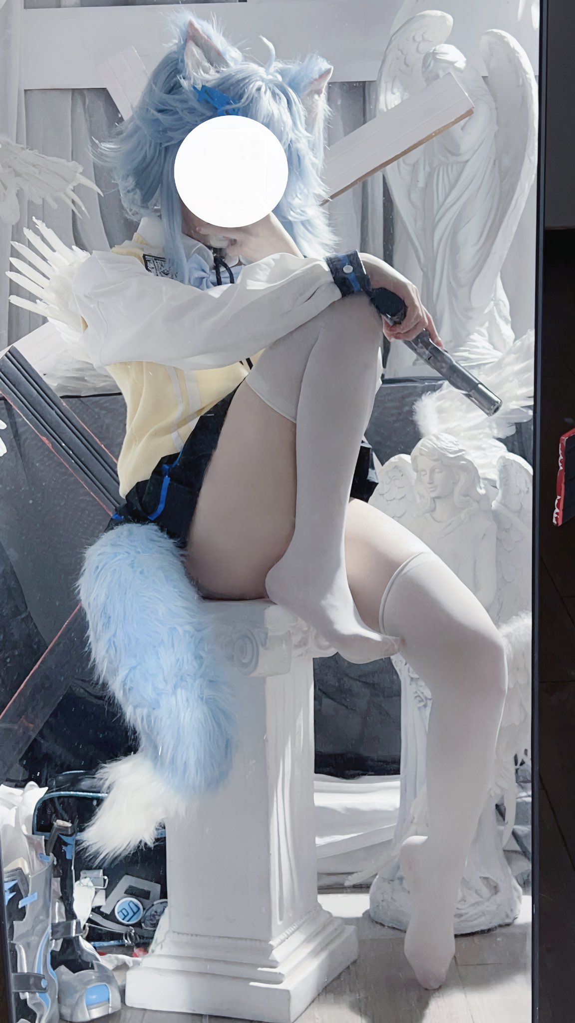 蓝头发的女人坐在一个雕像上。