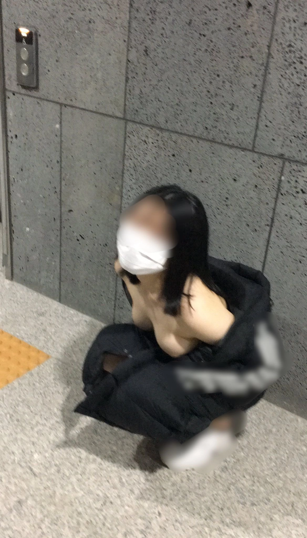 戴着面具的女人坐在地上。