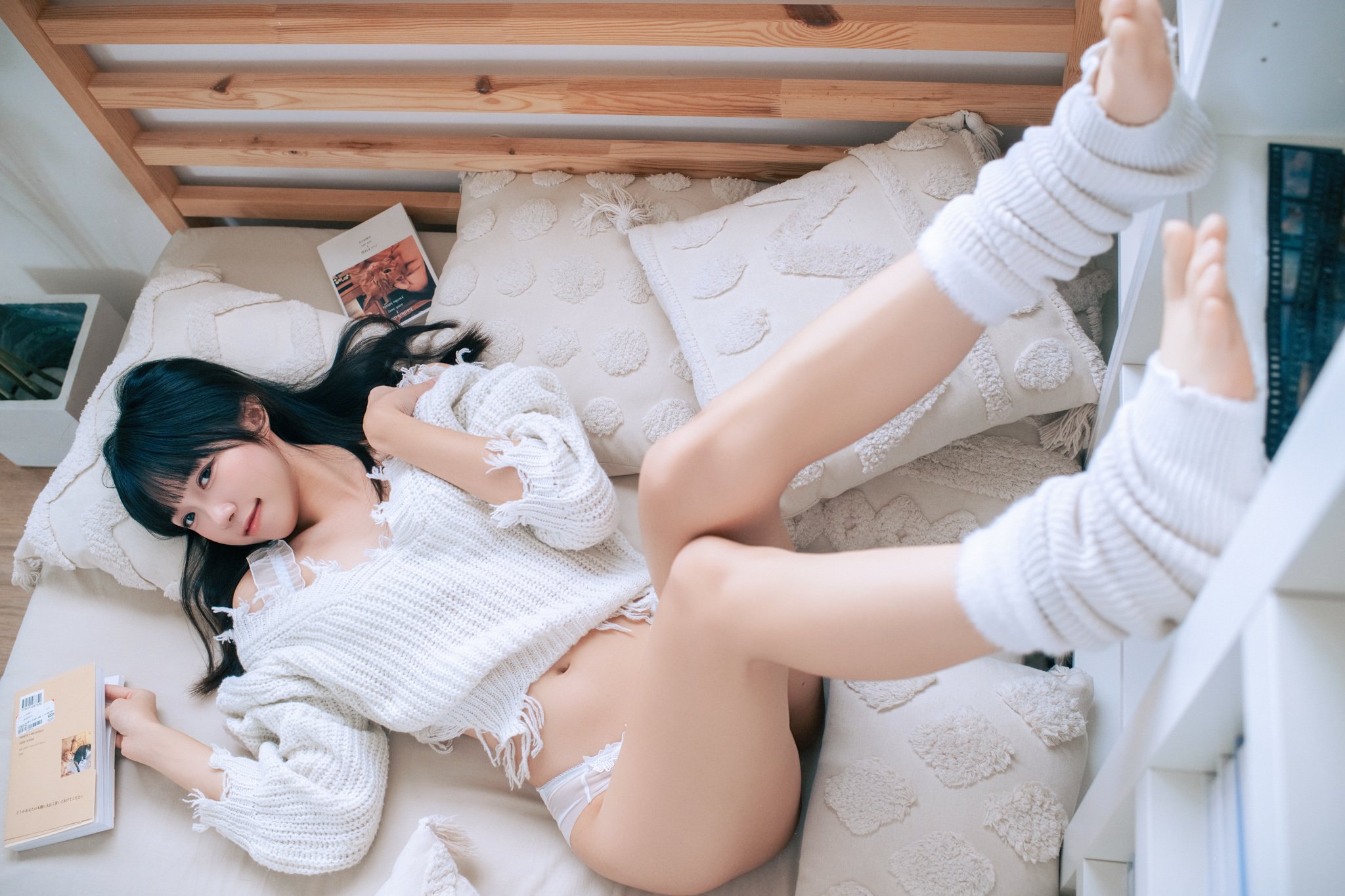 女人躺在床上,带着一本书。