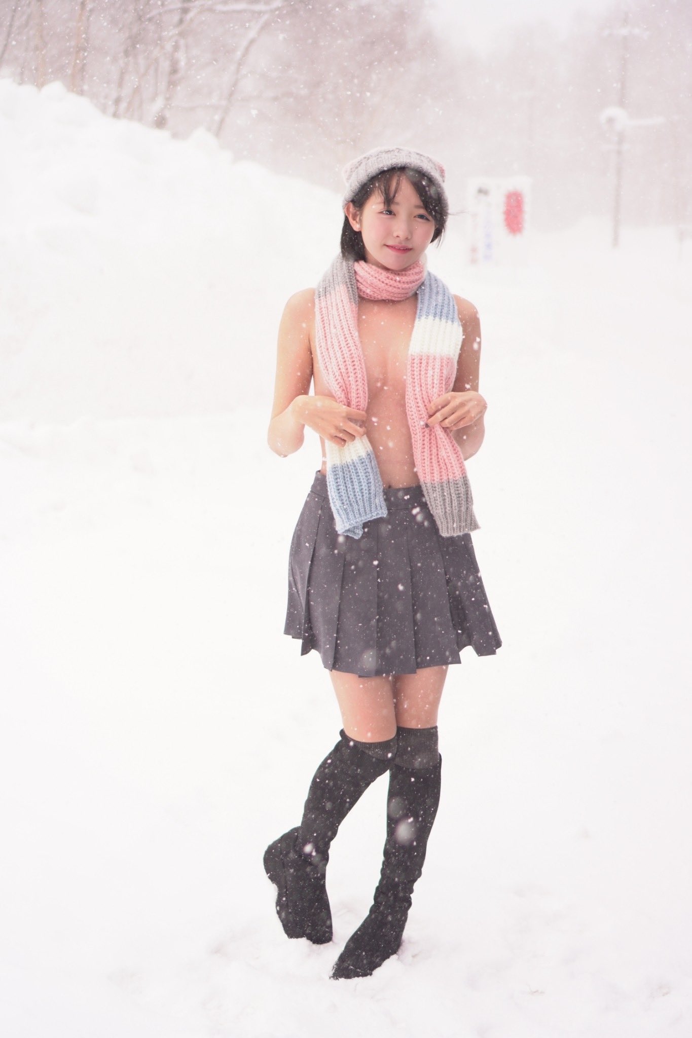 穿着黑色裙子和一件衬衫的女人站在雪地上。