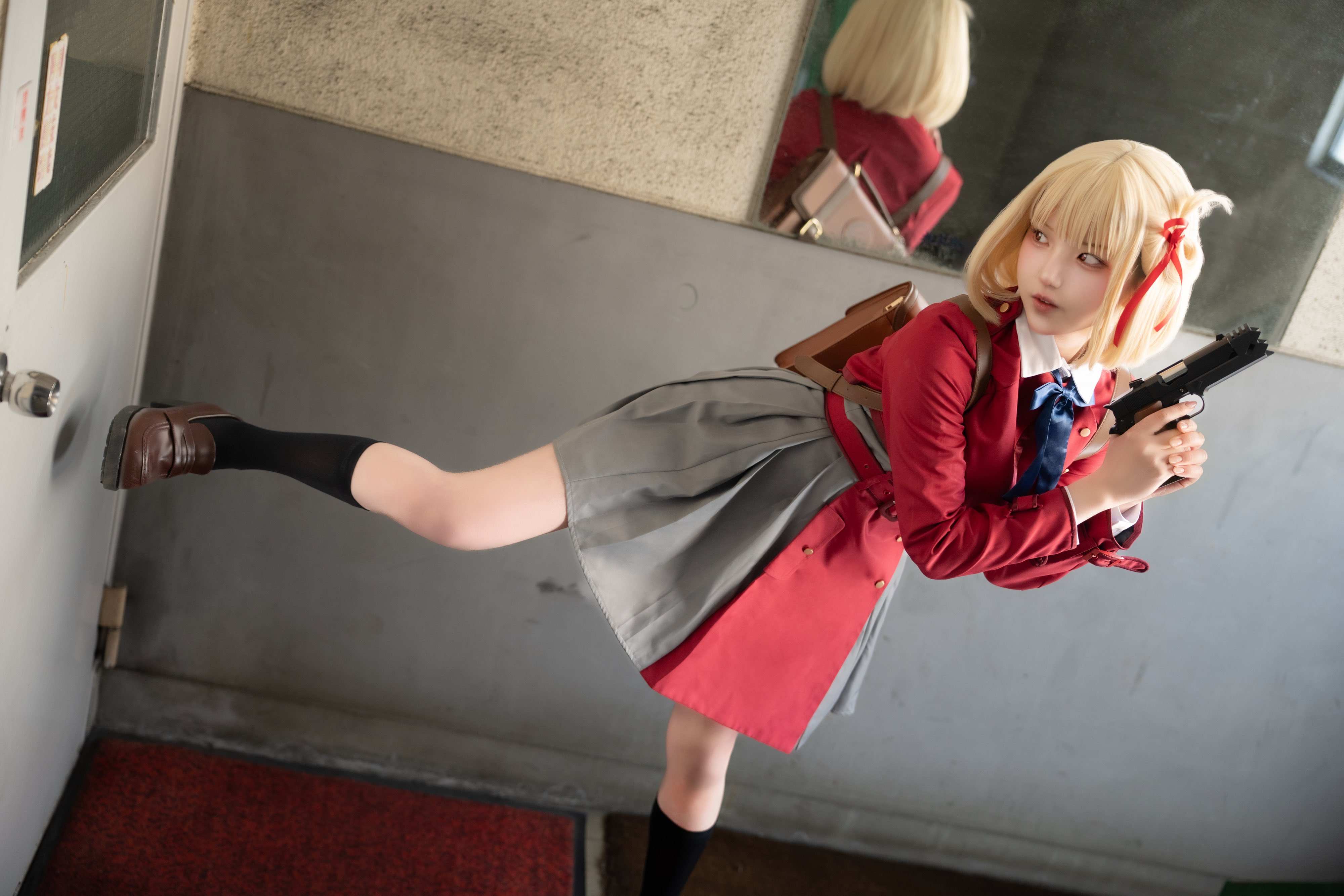 穿着红色外套和灰色裙子的女人拿着一把枪。