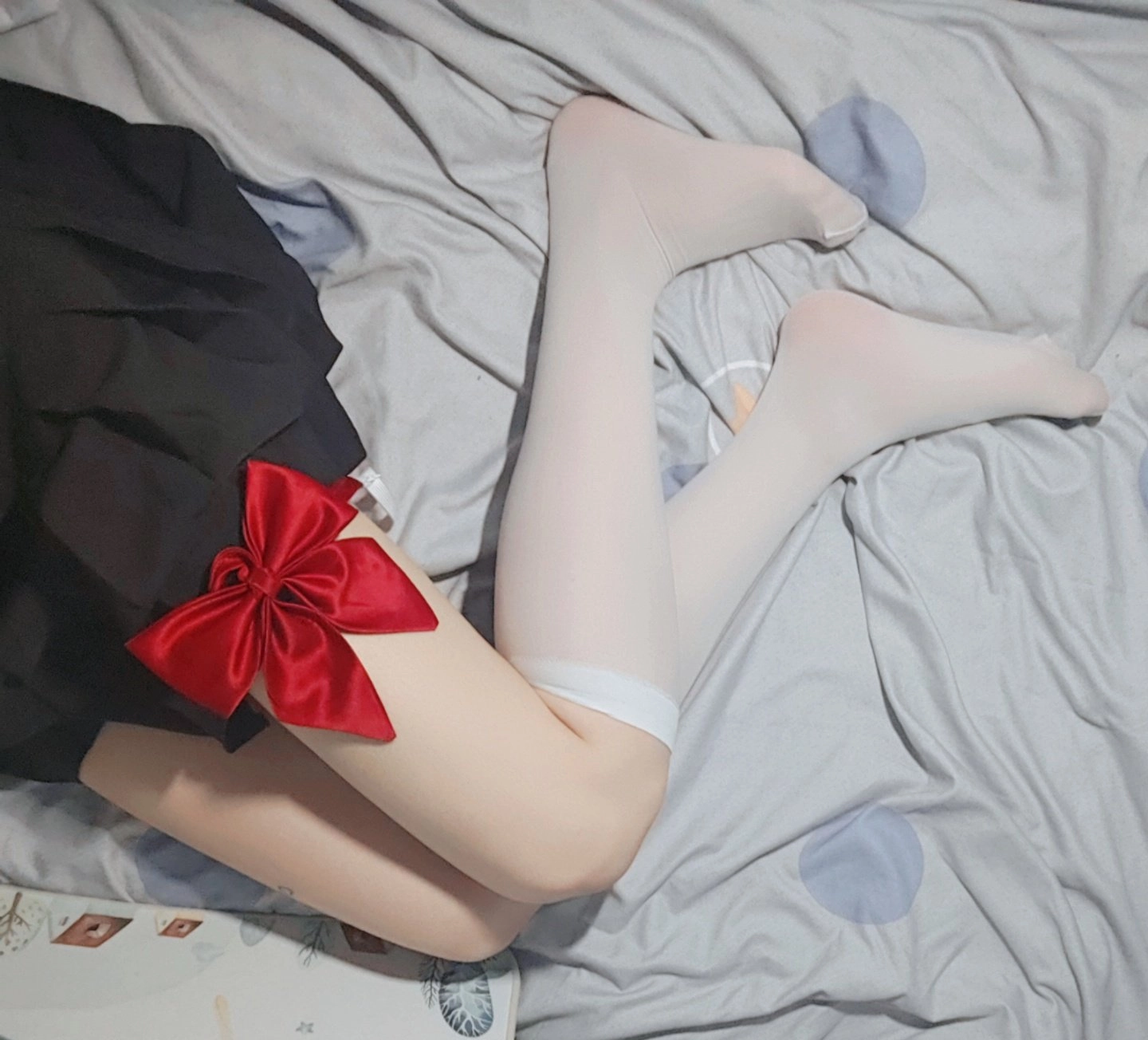 女人穿着一件黑色的裙子,有一条红色的弓。