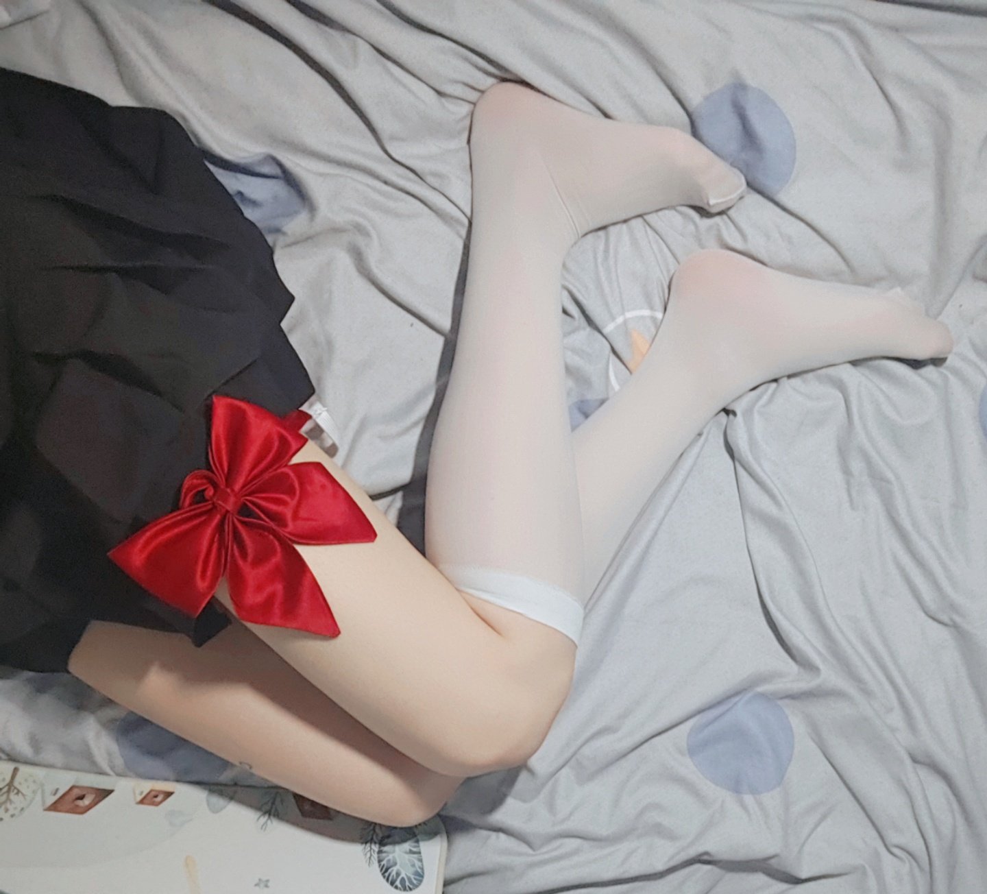 女人穿着一件黑色的裙子,有一条红色的弓。