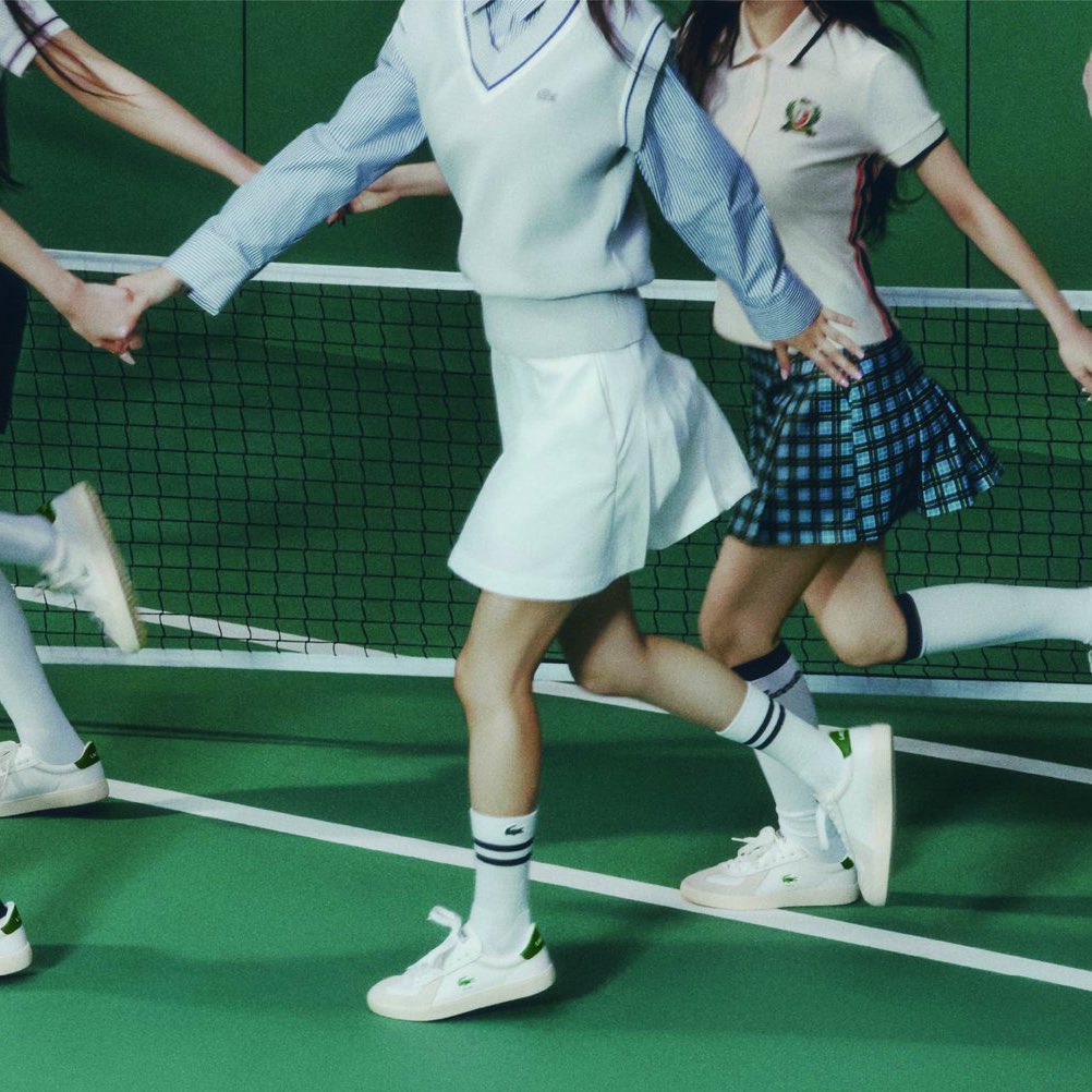 三个女孩在网球场上奔跑。