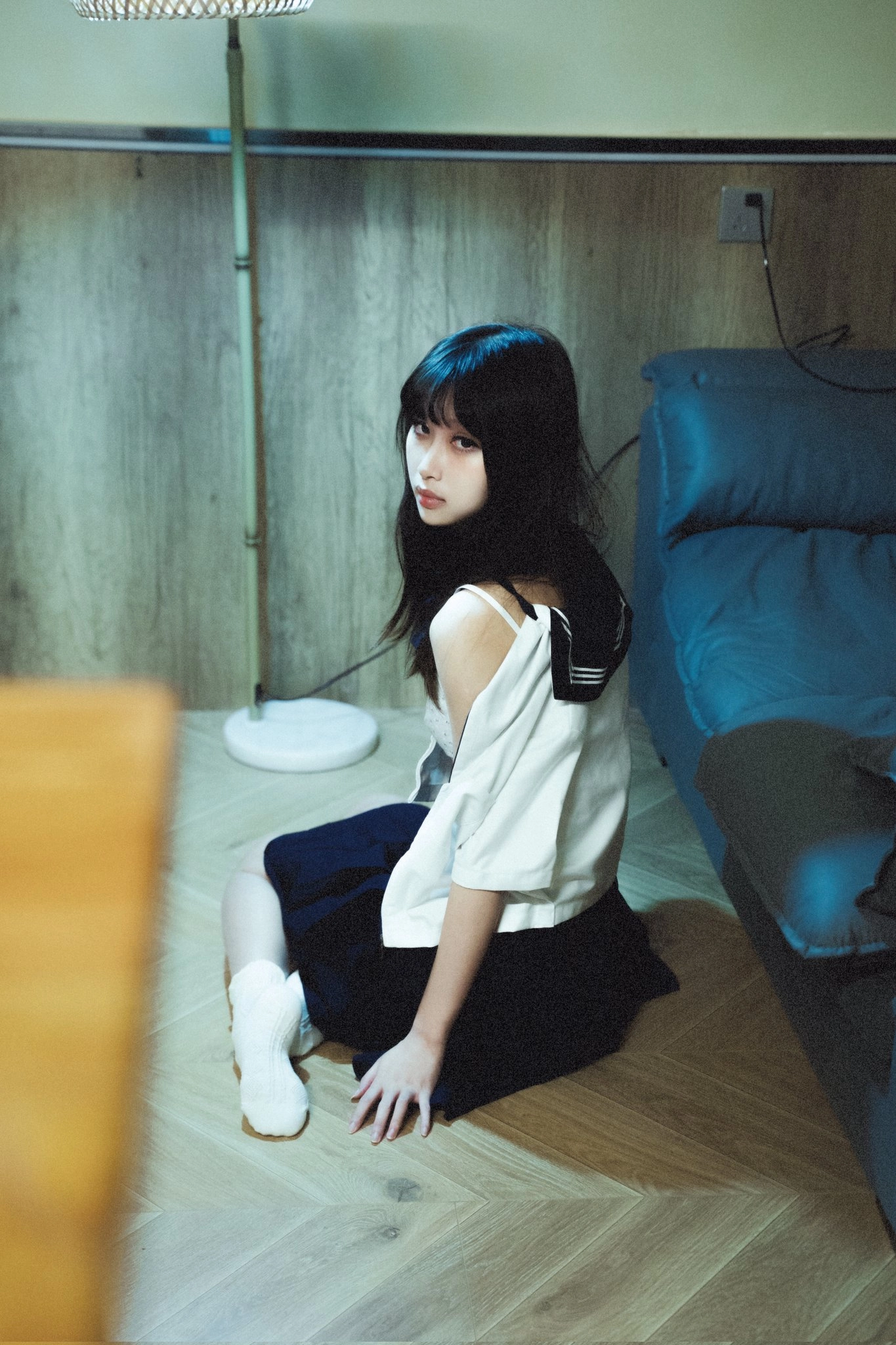 穿着白色衬衫和黑色衬衫的女人坐在地板上。