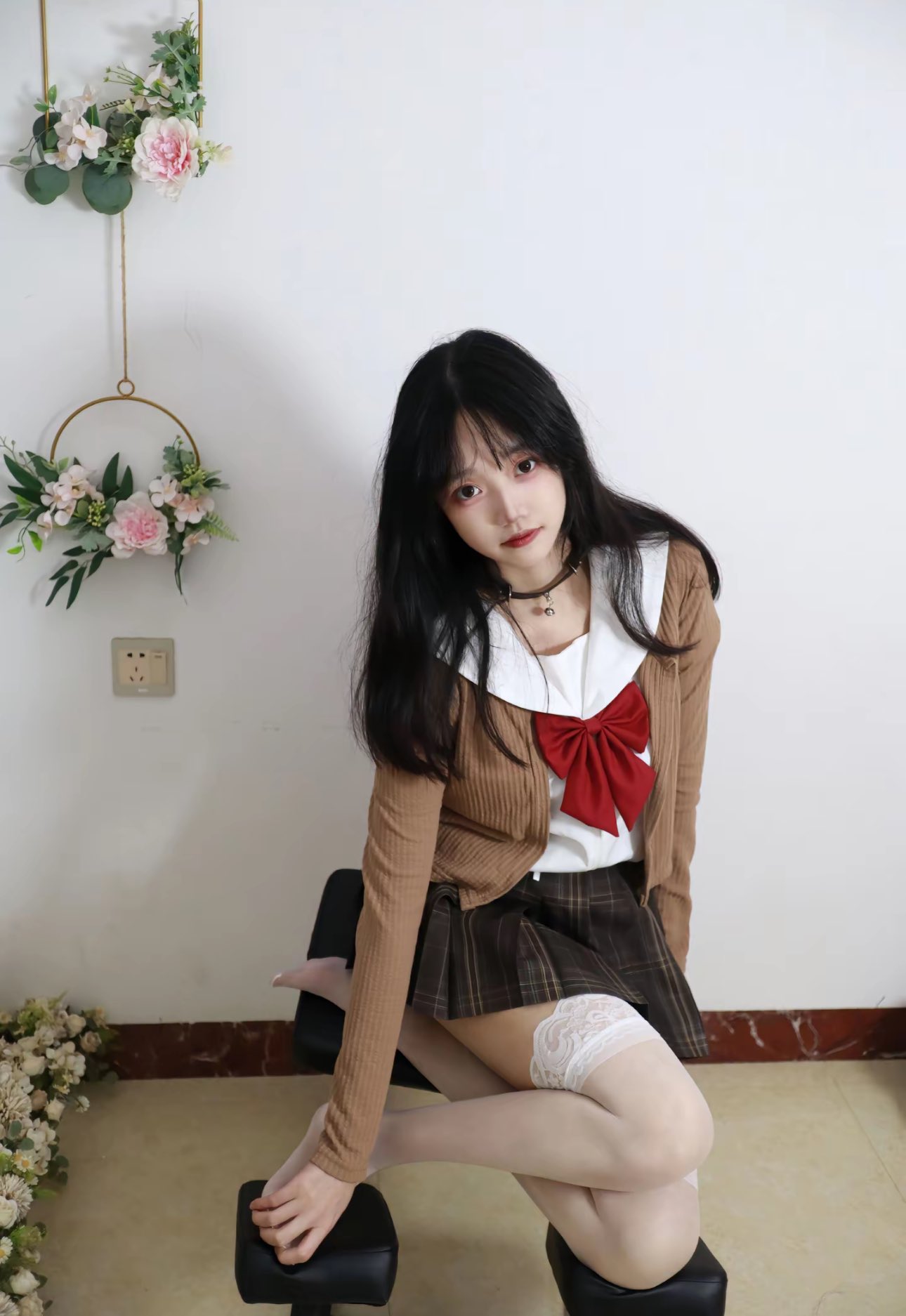 穿着校服的女孩坐在椅子上。