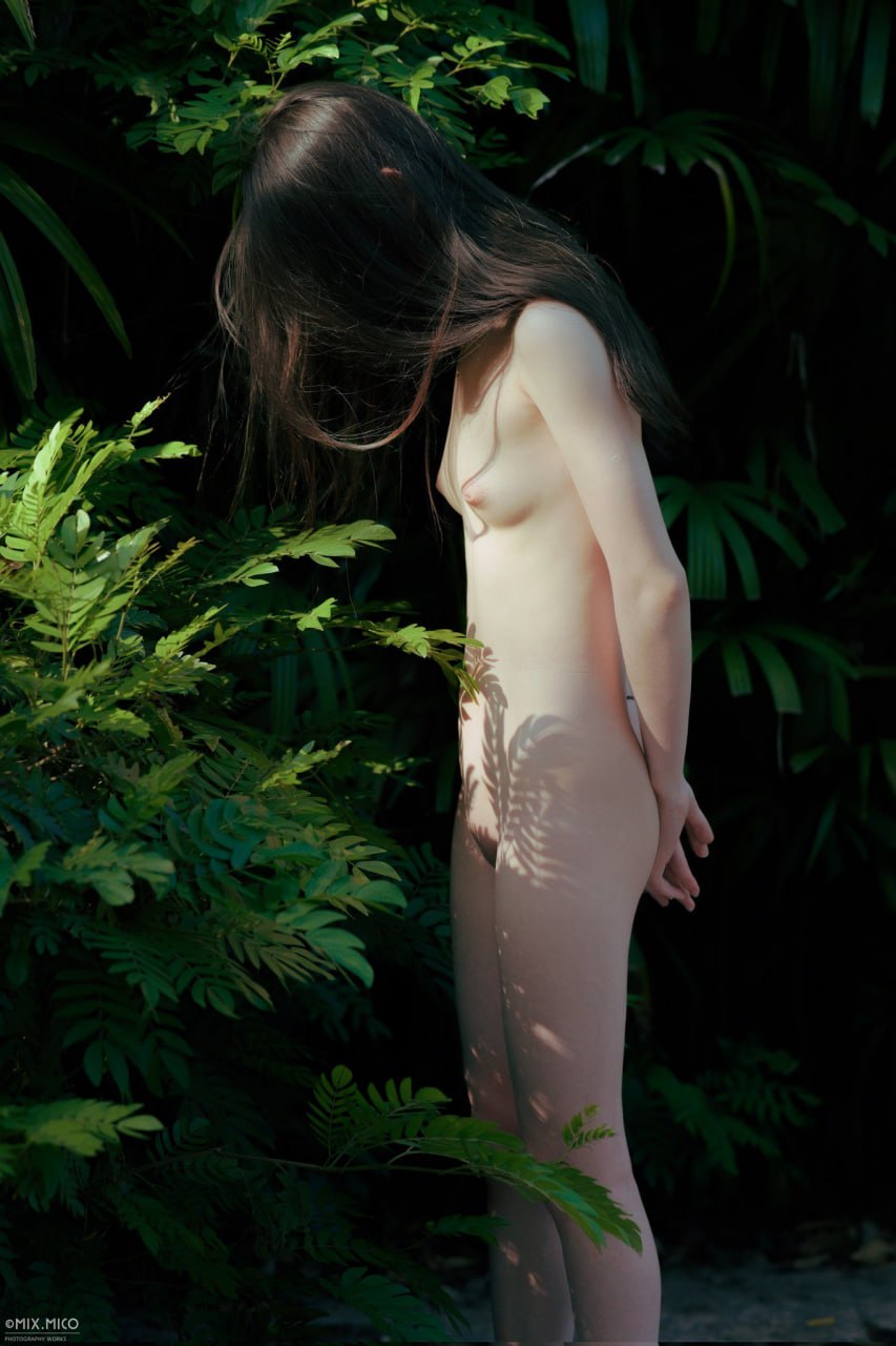 没有衬衫的女人站在森林前面。