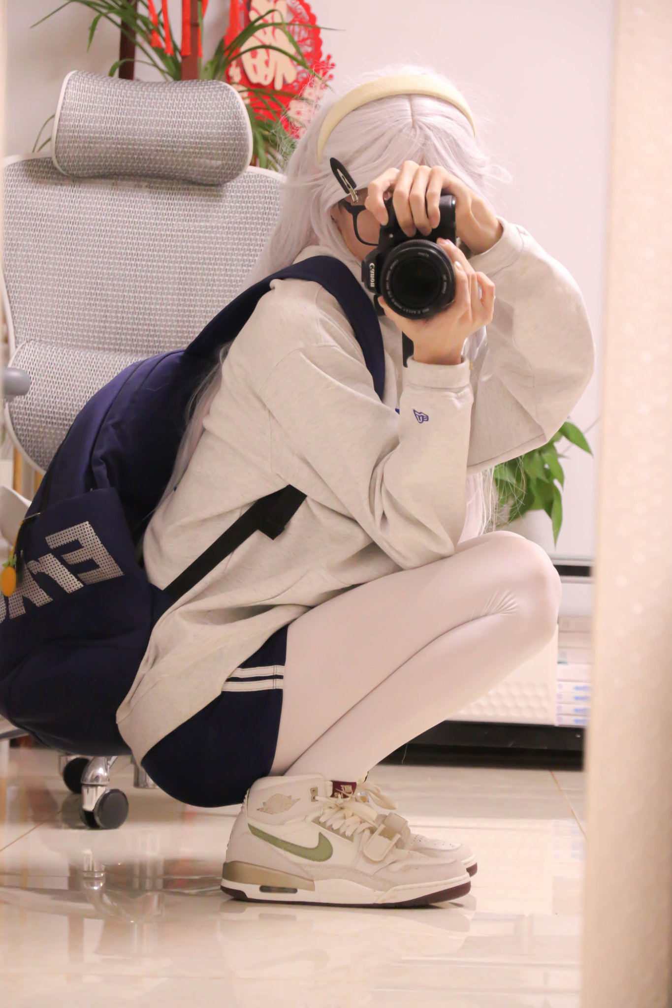 一位穿着蓝背包和白裤子的女孩正在拍照她的鞋子。