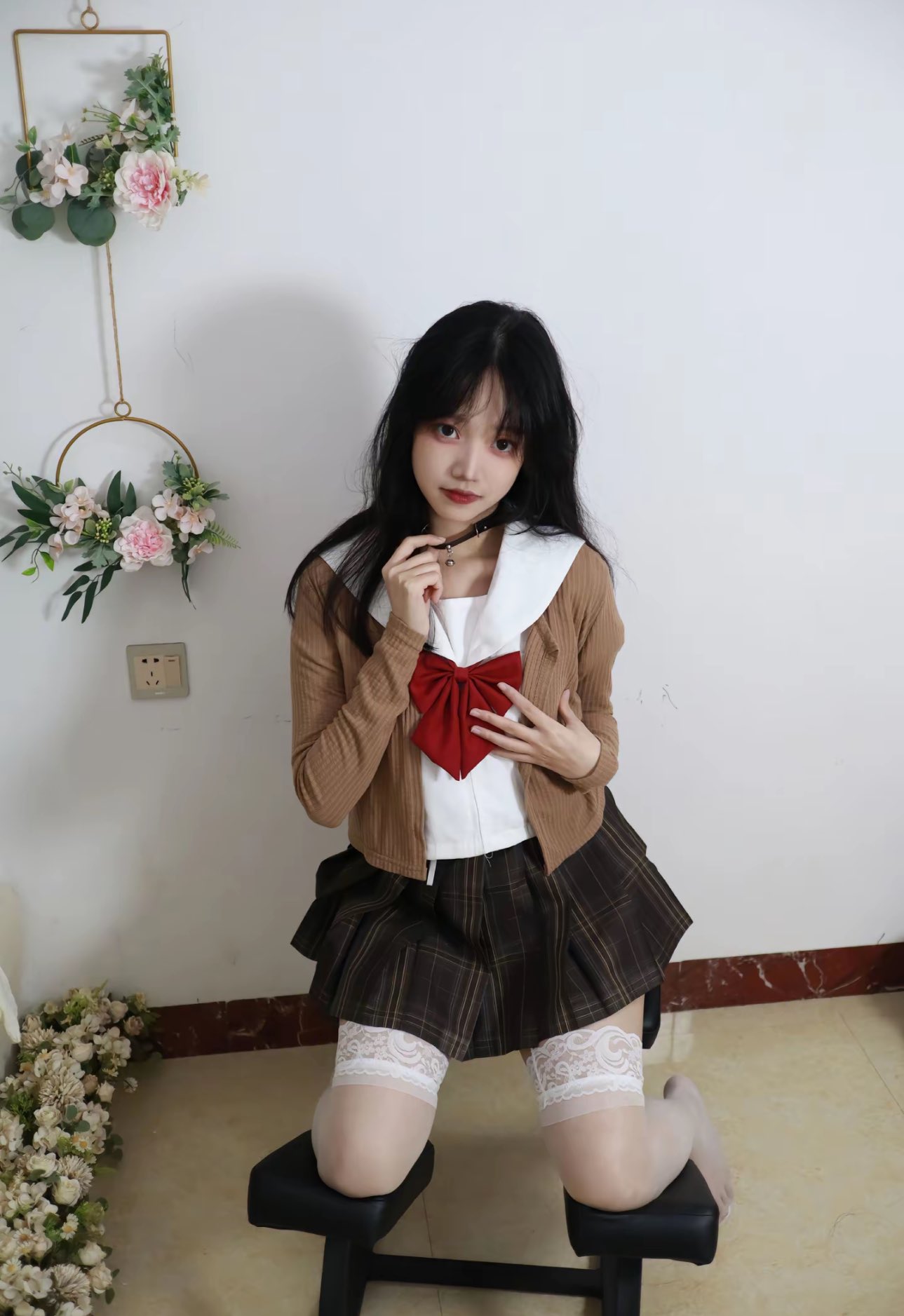 穿着校服的女孩坐在椅子上。