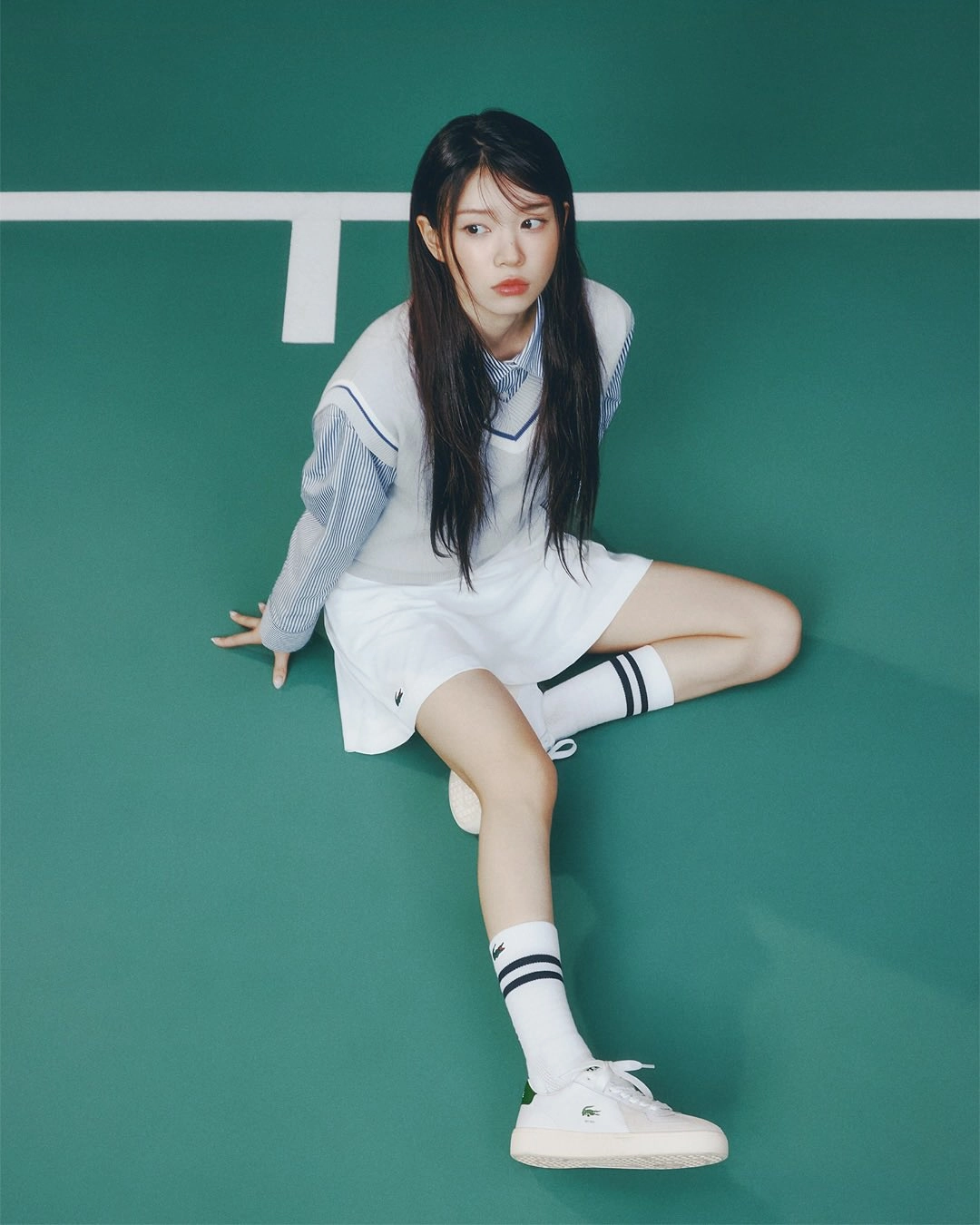 穿着白色衣服的女人坐在网球场上。