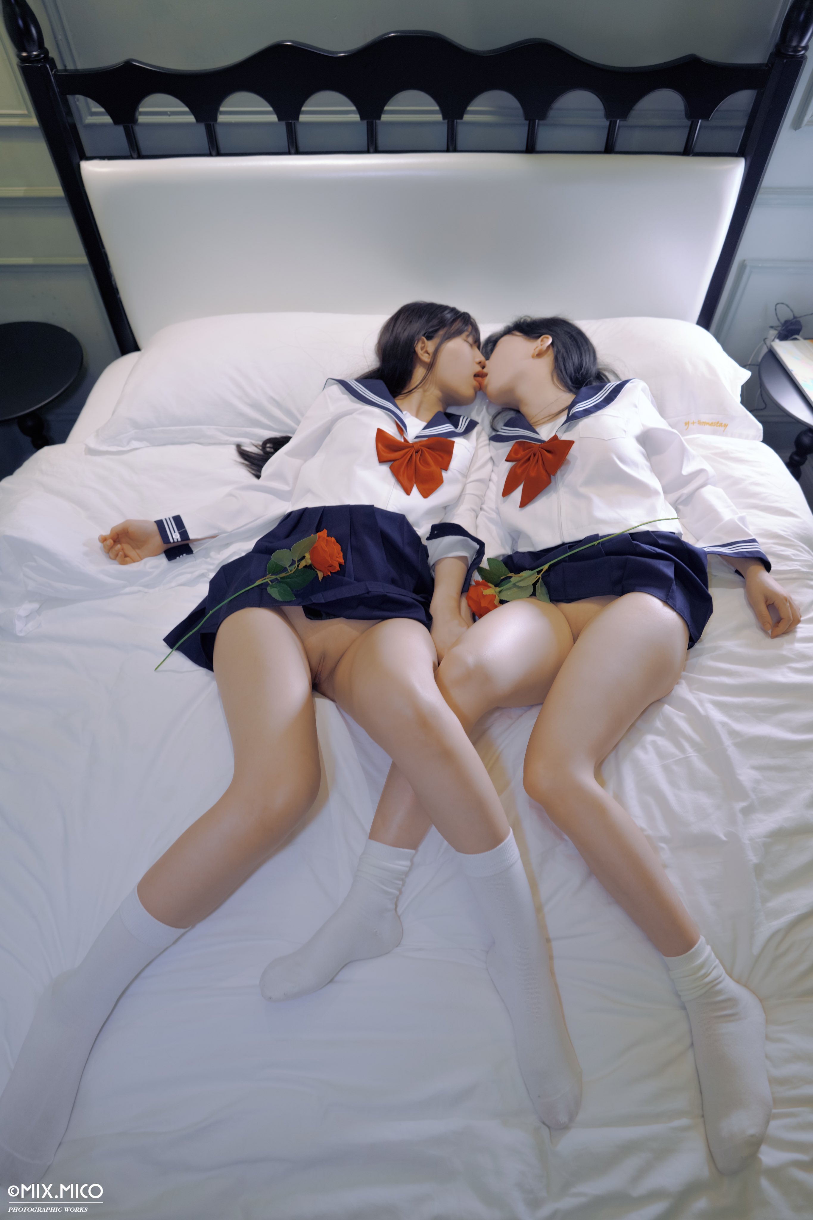 两个女孩在床上接吻。