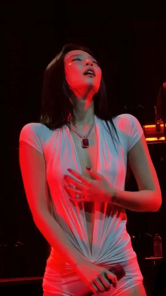 一位穿着白色衬衫和项链的女人正在打开她的衬衫。