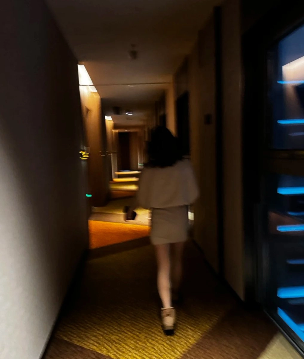 一位穿着白色衣服的女人走在走廊上。