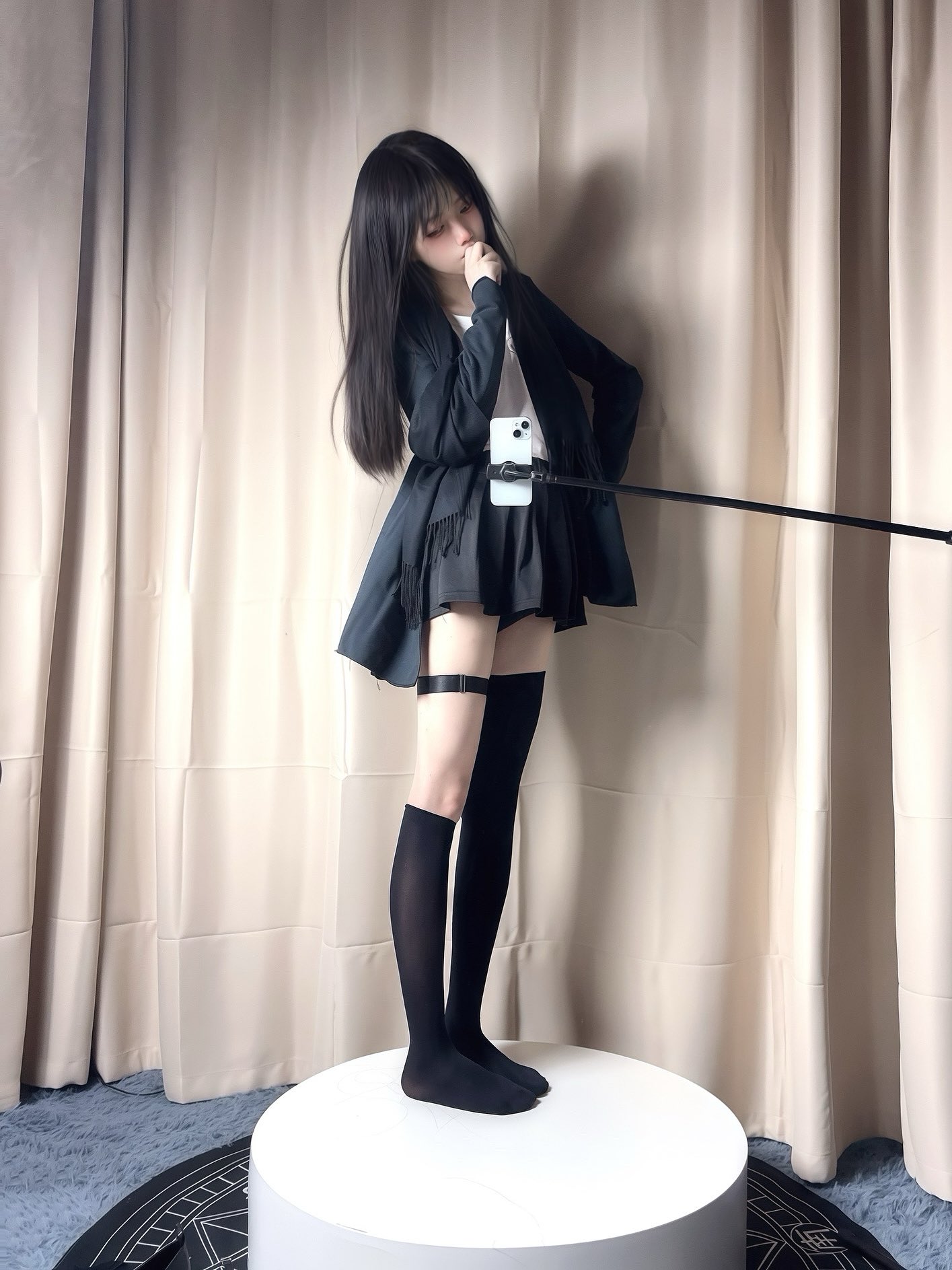 穿着黑色裙子和黑色袜子的女人站在一个白色的椅子上。