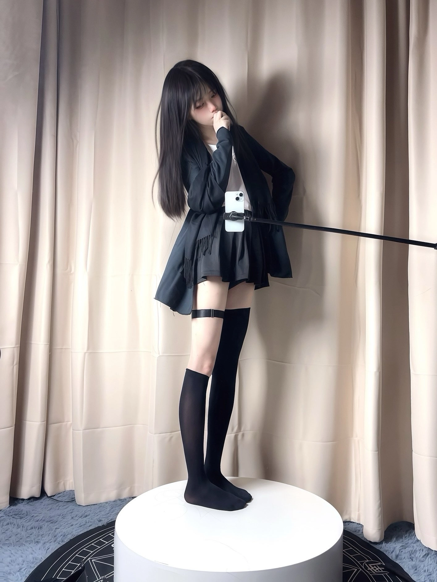 穿着黑色裙子和黑色袜子的女人站在一个白色的椅子上。