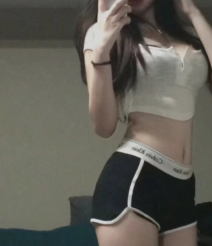 一位穿着短裤和一件白色衬衫的女人正在拍自拍。