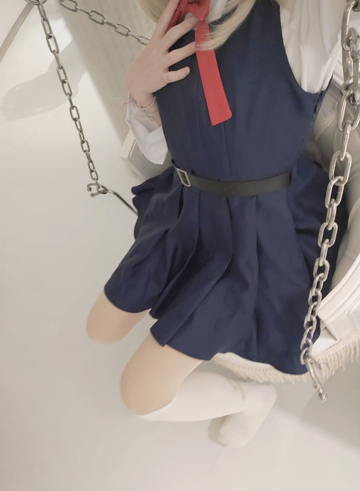 穿着蓝色衣服的女孩坐在一个滑板上。